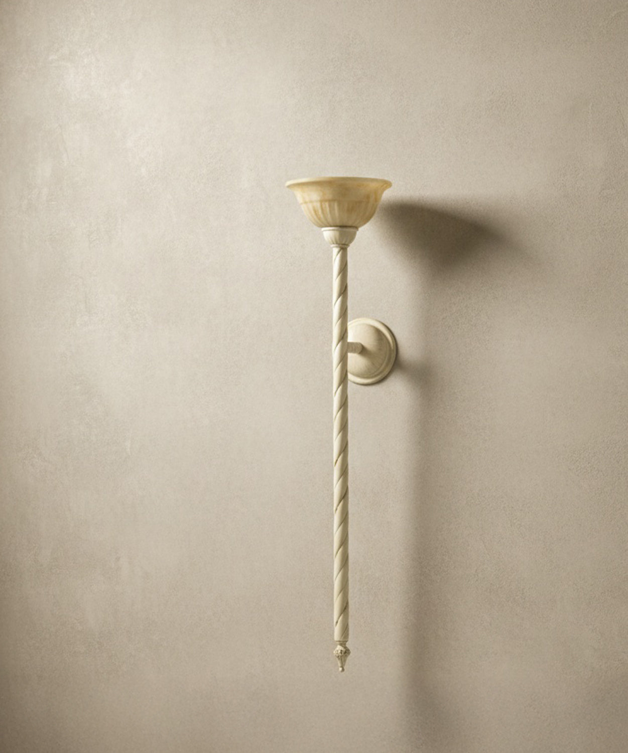 Aplique "La Flambeau" encendido sobre una consola de madera rústica con libros antiguos y vasija de barro, luz cálida.