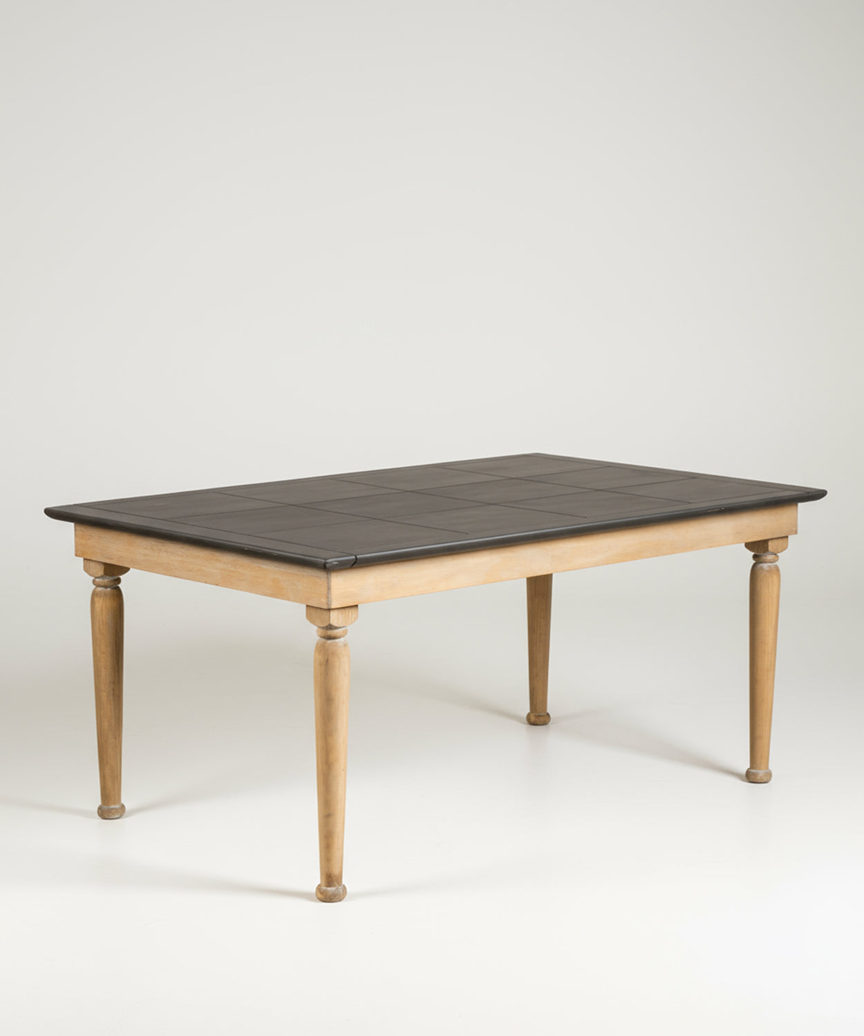 Mesa de comedor rectangular de estilo rústico con patas de madera natural y superficie oscura, fotografiada de frente en un estudio con fondo blanco.