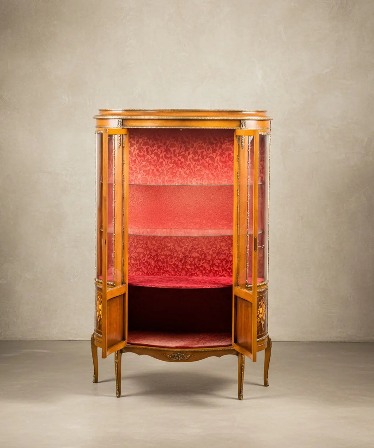 Interior de vitrina de lujo mostrando el tapizado carmesí y baldas de cristal.