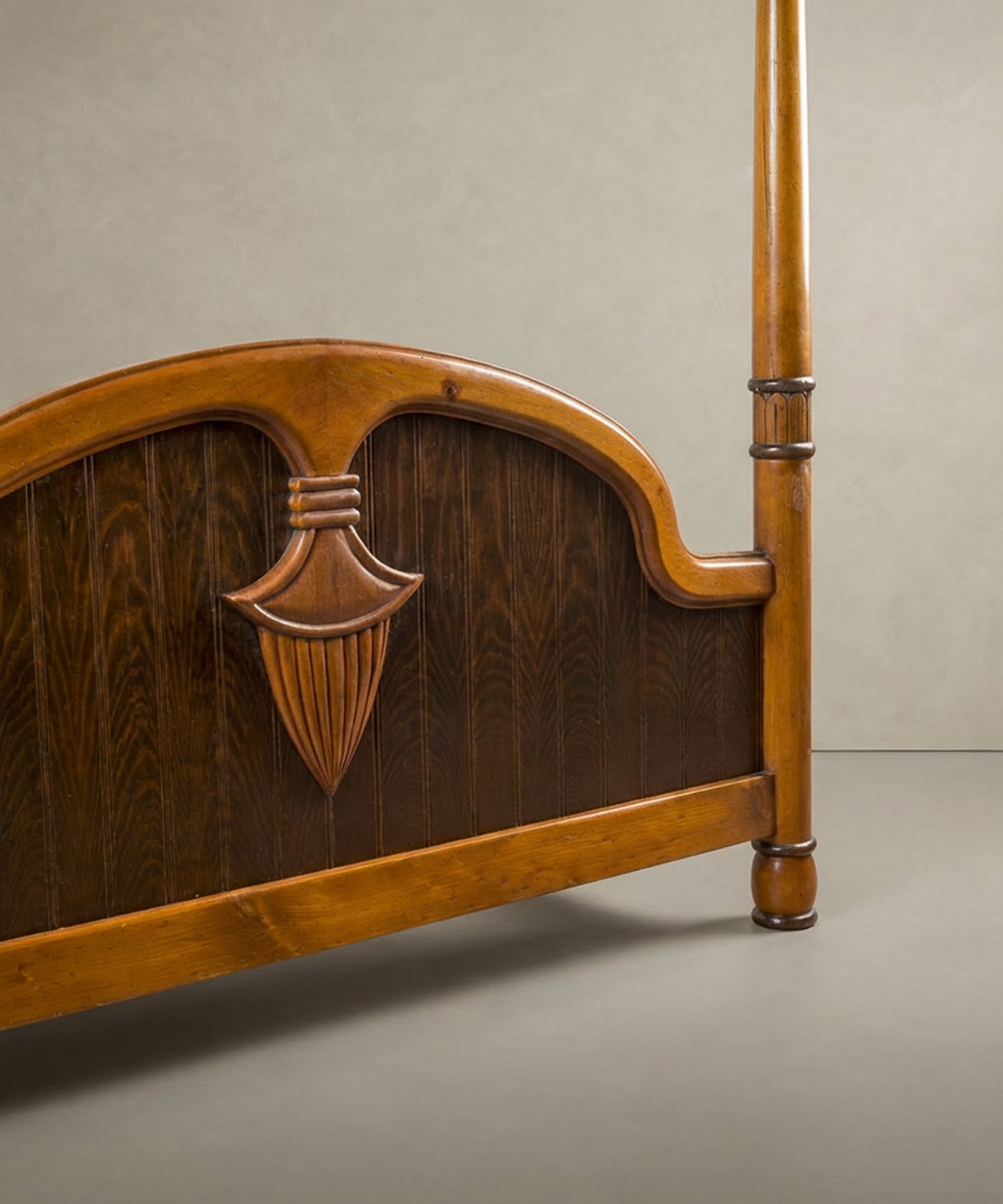 Perspectiva lateral del piecero con paneles verticales y acabado bitono en madera noble.