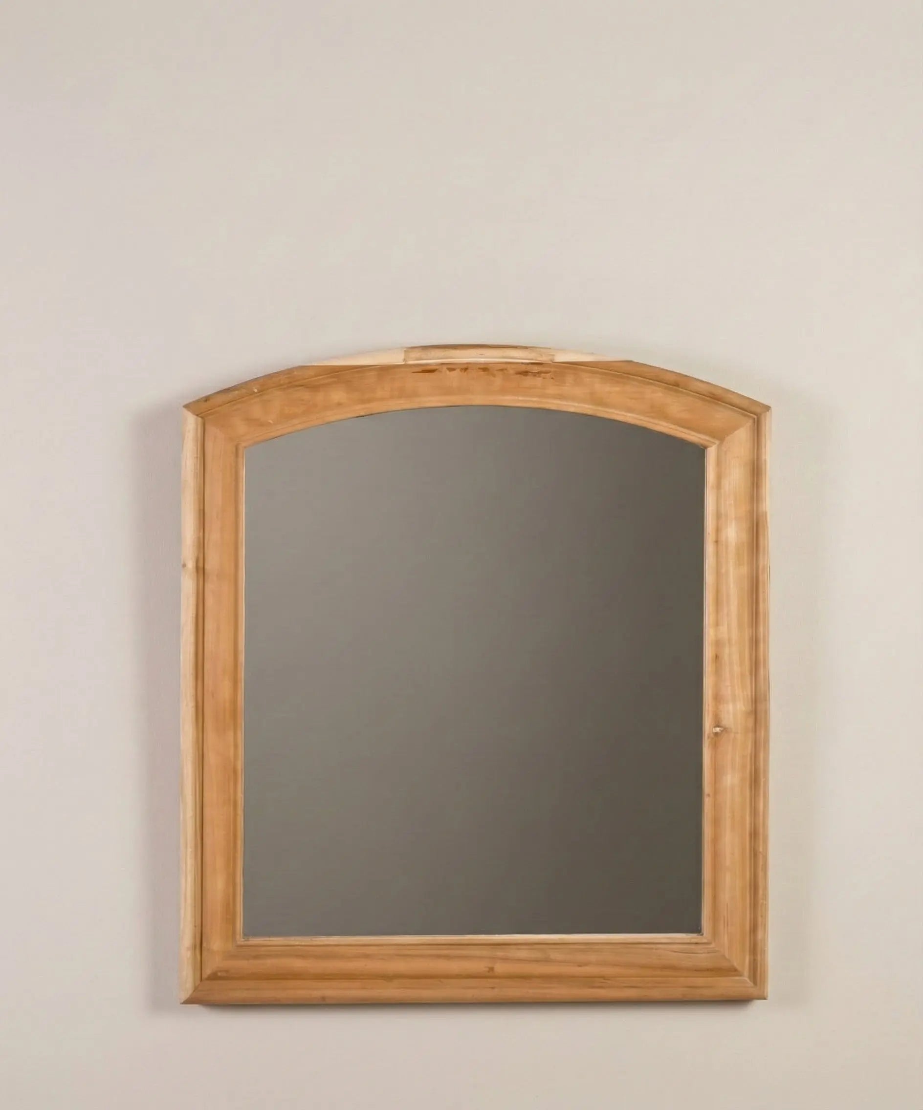 Detalle del marco de madera color miel del espejo con forma de arco