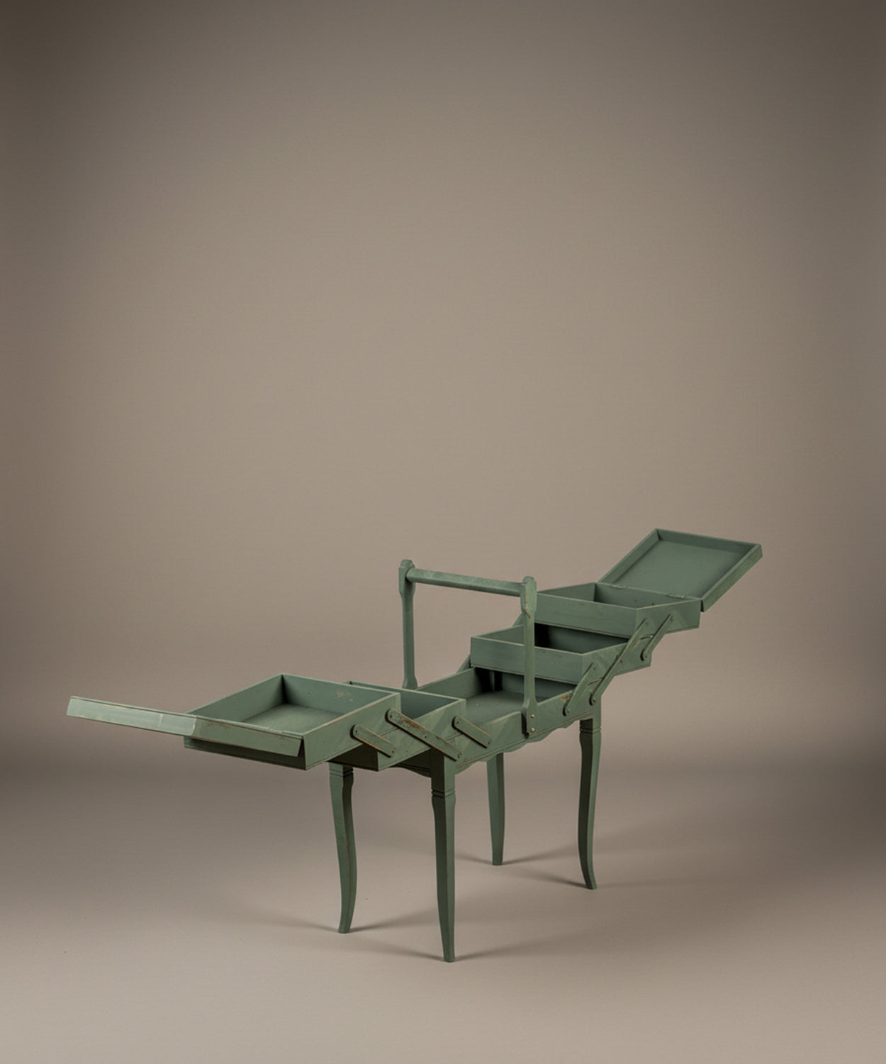 Costurero antiguo de madera totalmente desplegado mostrando compartimentos interiores escalonados