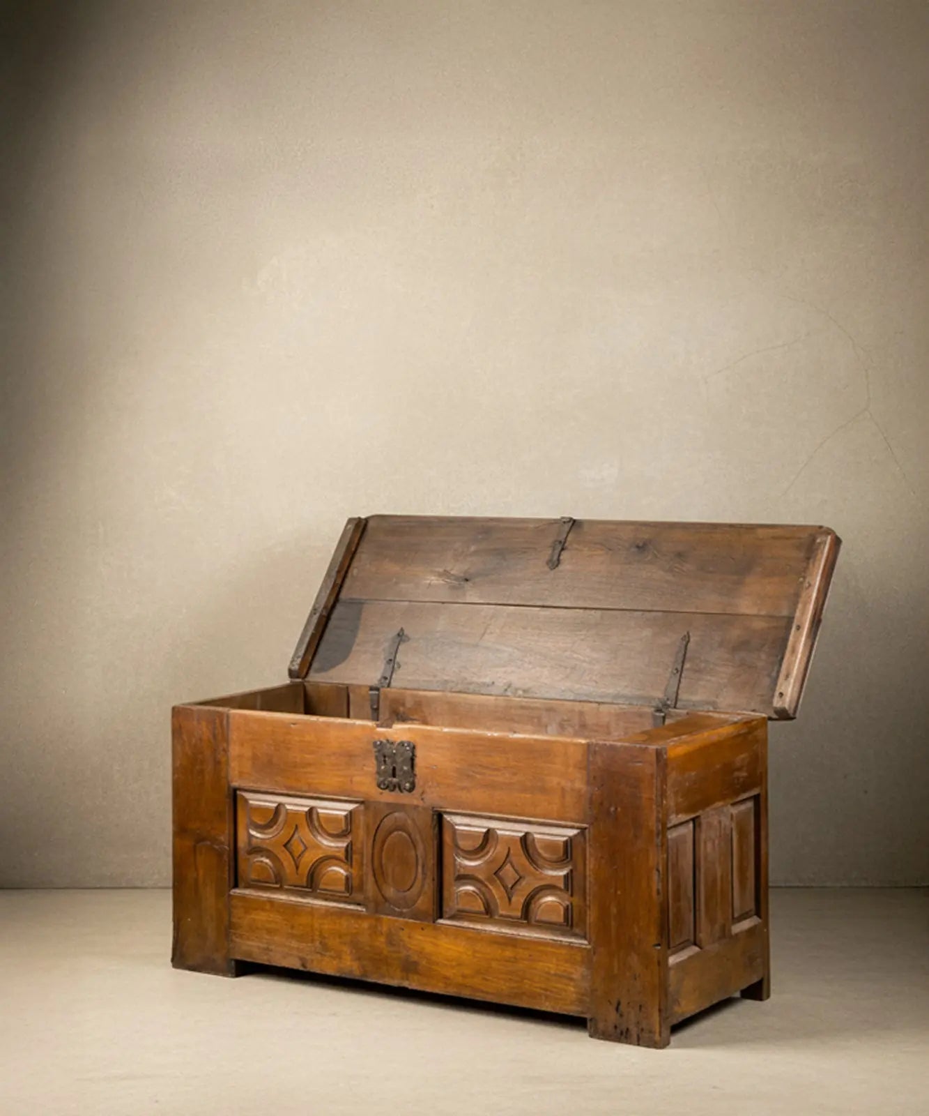 Interior del arcón de madera mostrando las bisagras de lanza y el compartimento lateral secreto.