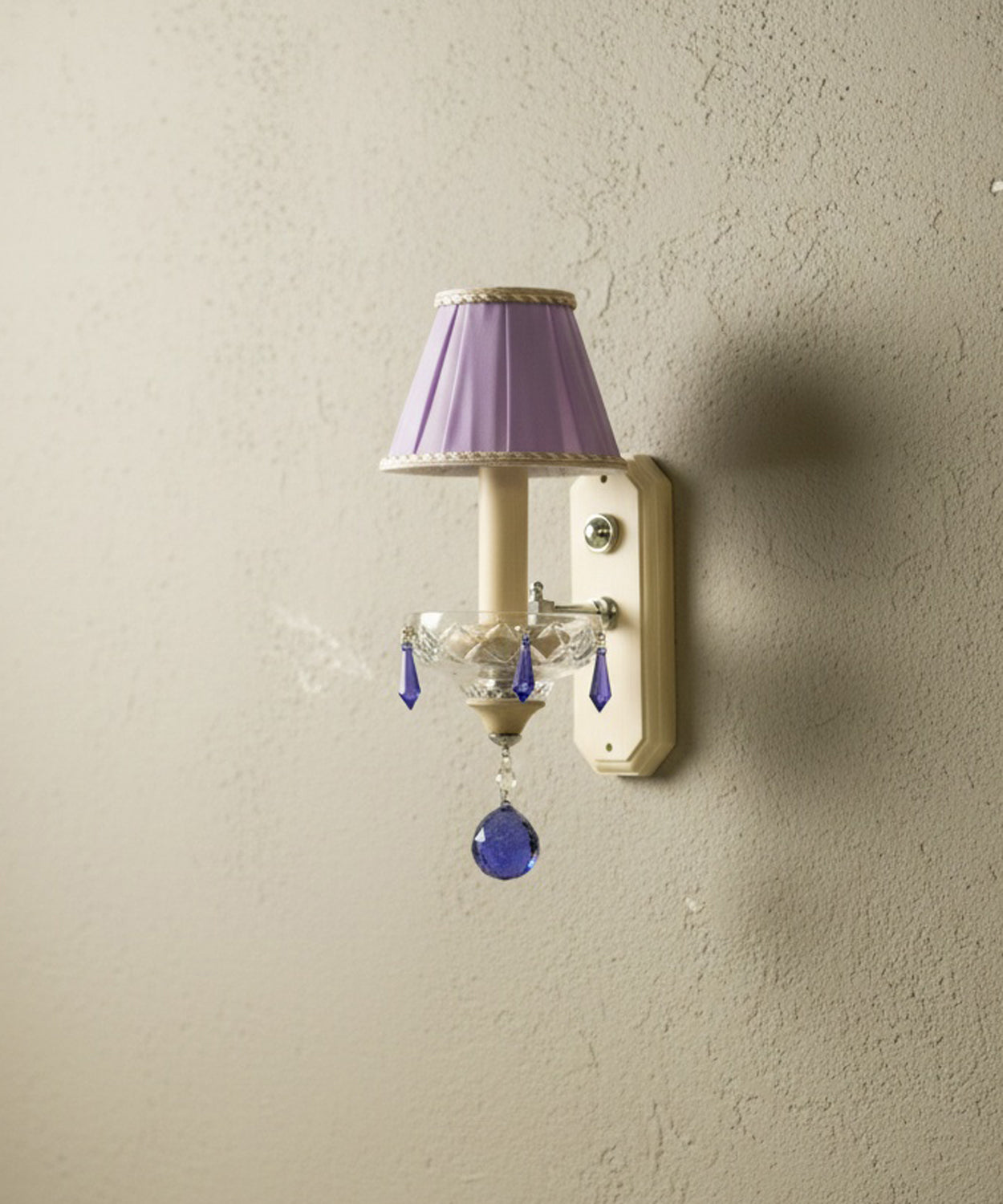 Vista en ángulo que resalta la textura del plisado de la pantalla y el brillo de las lágrimas de cristal de Swarovski.