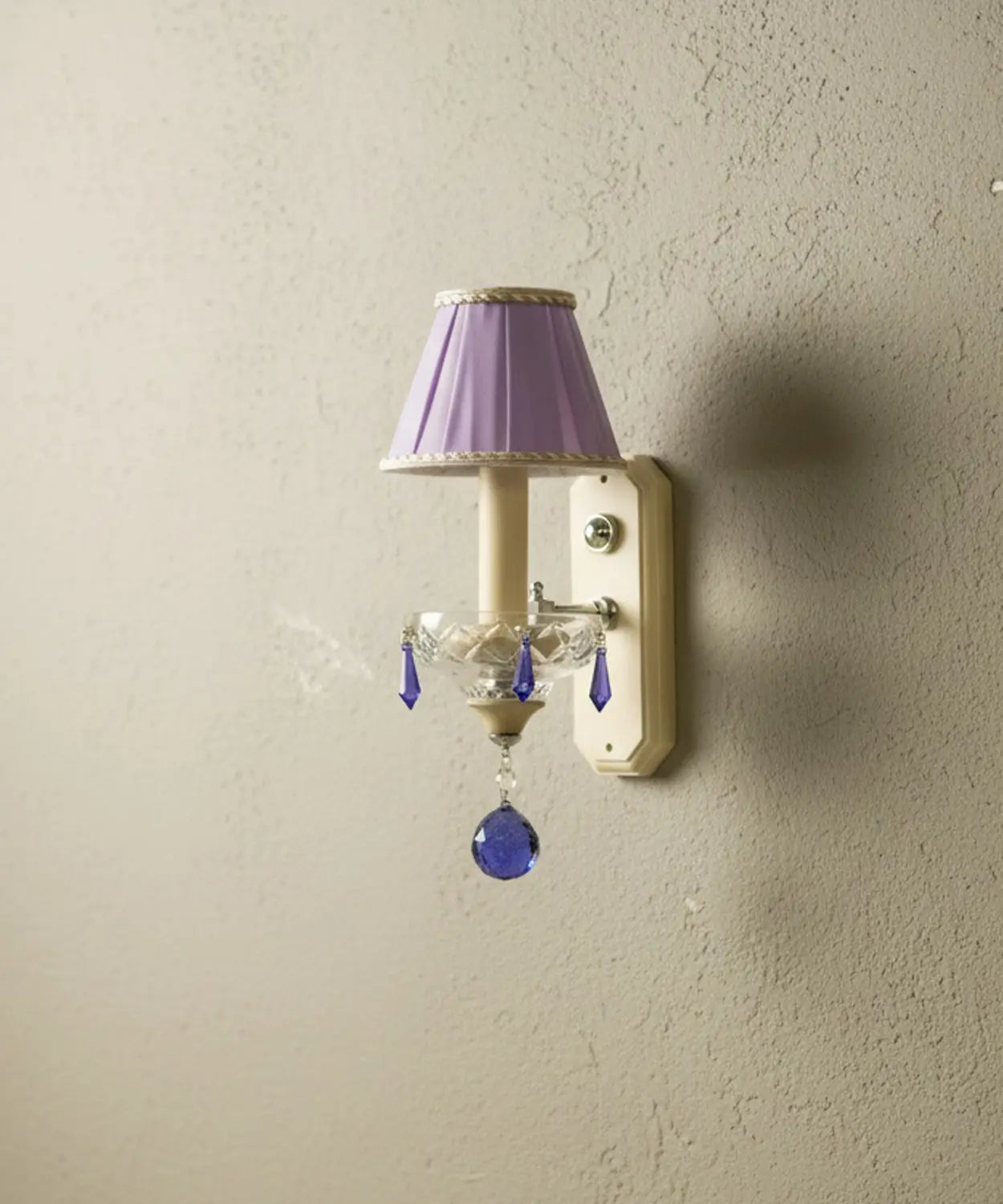 Vista en ángulo que resalta la textura del plisado de la pantalla y el brillo de las lágrimas de cristal de Swarovski.