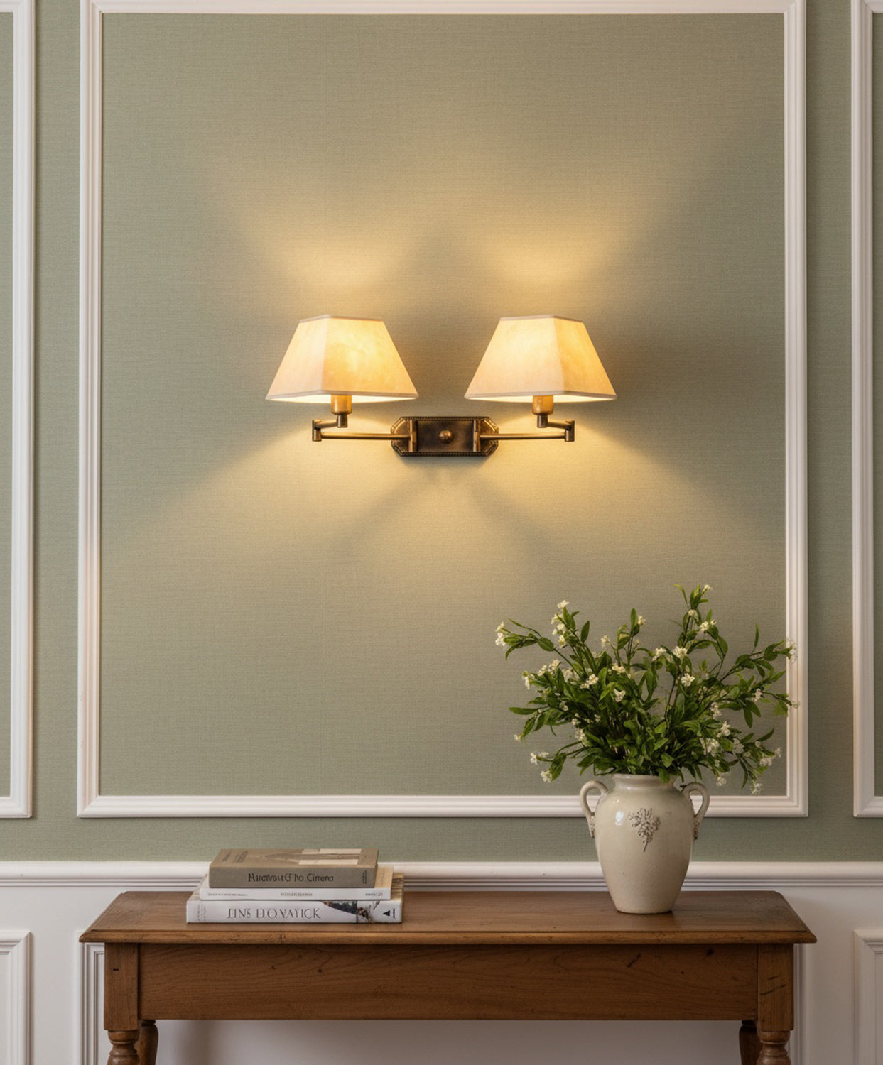 Decoración de salón clásico con iluminación de aplique doble resaltando molduras de pared verdes.