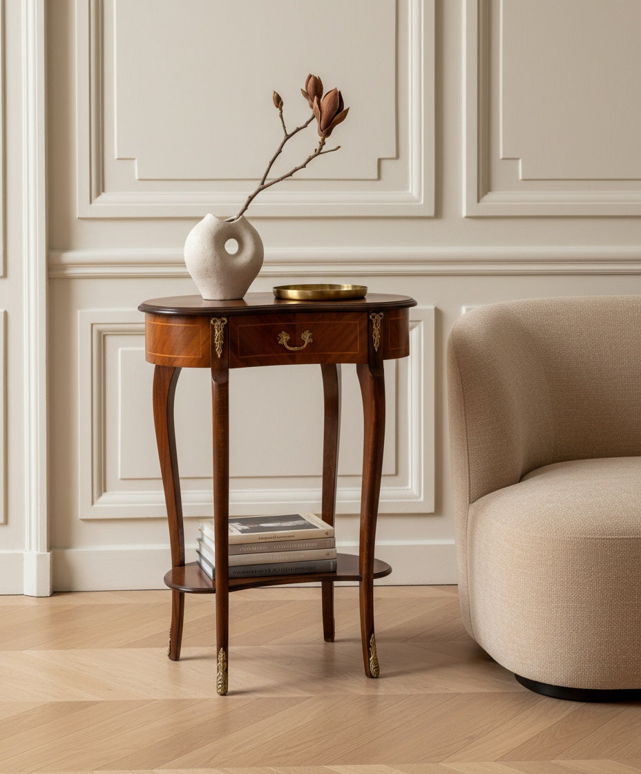 Mesa auxiliar decorada con libros y flores en un ambiente de biblioteca clásica con estanterías y cortinas.
