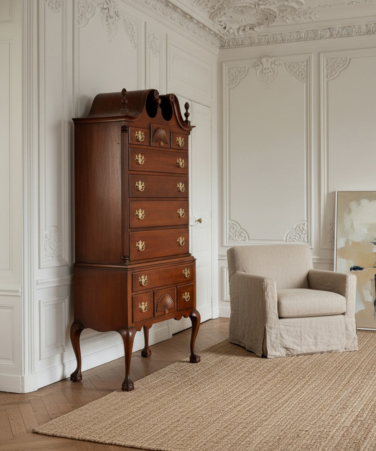 Mueble Highboy de caoba estilo Queen Anne en salón con molduras blancas y parquet.
