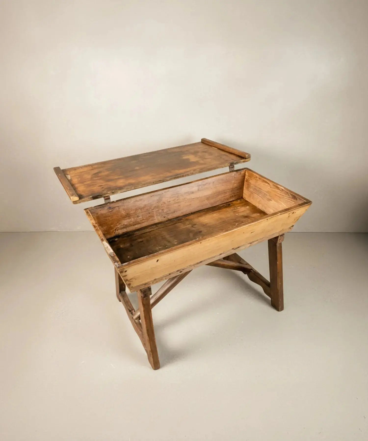 Artesa de madera del siglo XIX con tapa abierta mostrando el espacio de almacenamiento interior.