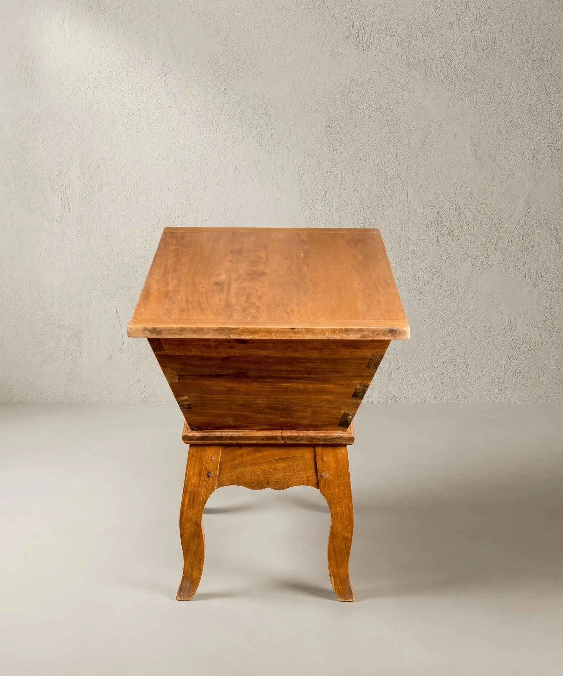 Perfil lateral de un mueble de almacenaje rústico tipo masera de panadero con patas cabriolé.