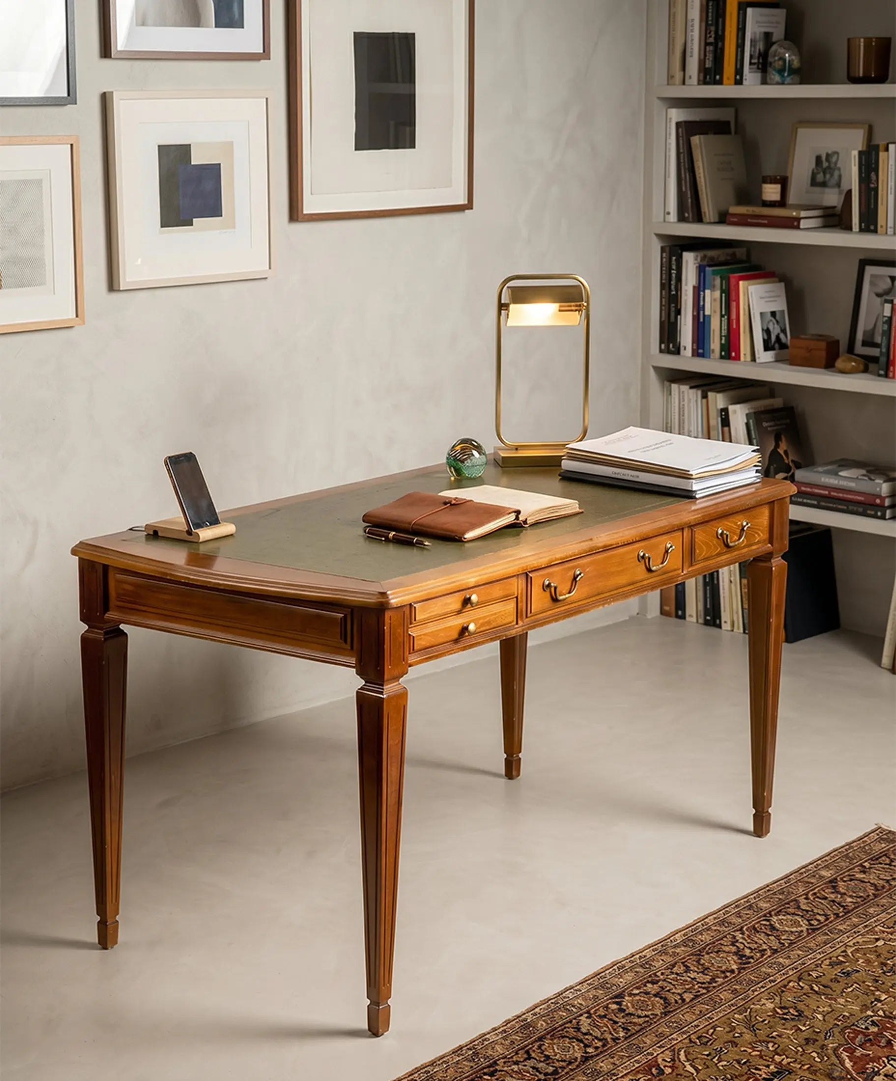 Escritorio clásico de nogal con tapa de cuero verde decorando un estudio moderno y elegante.
