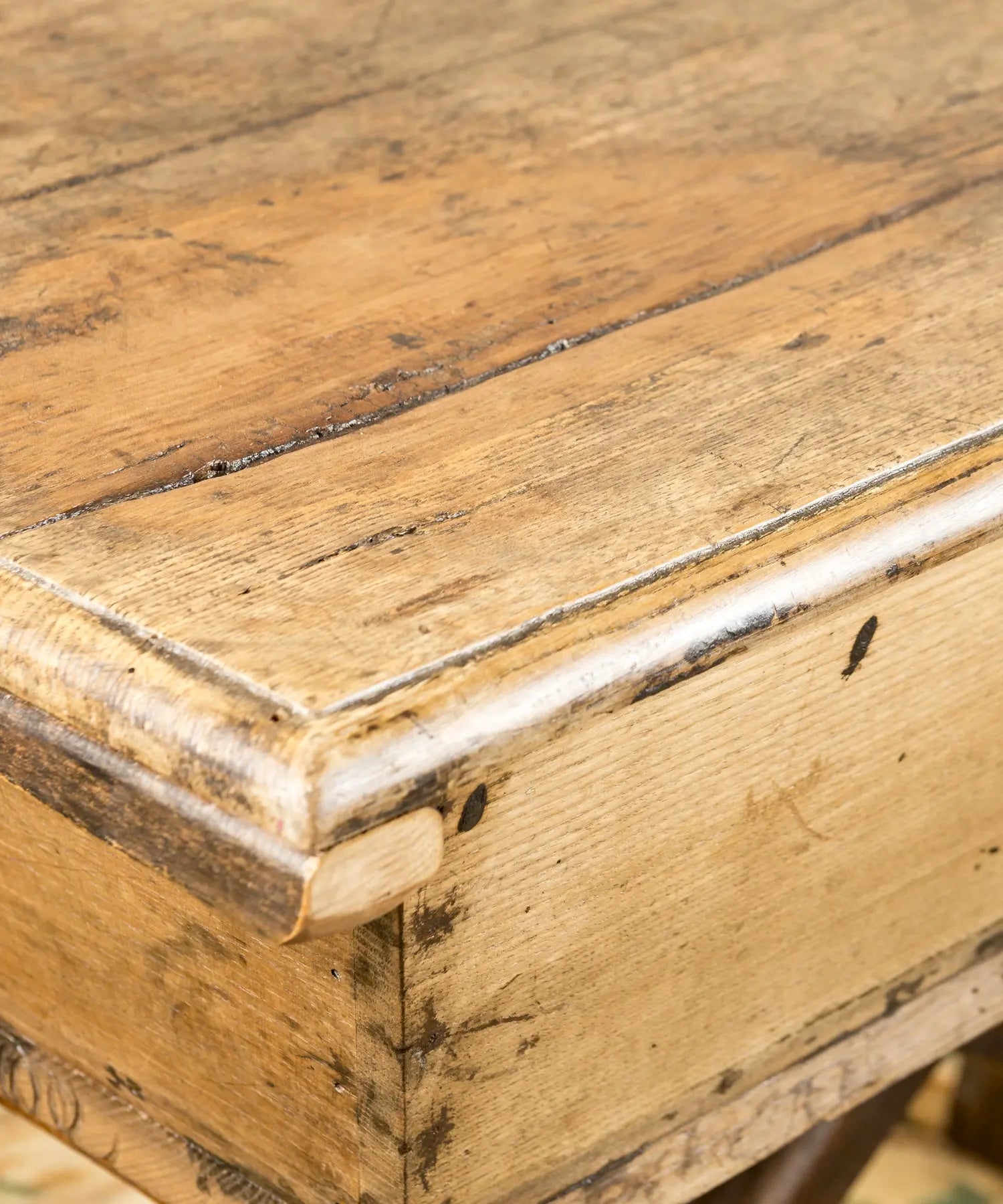 Perfil de mesa masera antigua mostrando la estructura de las patas en X y el acabado de la madera.