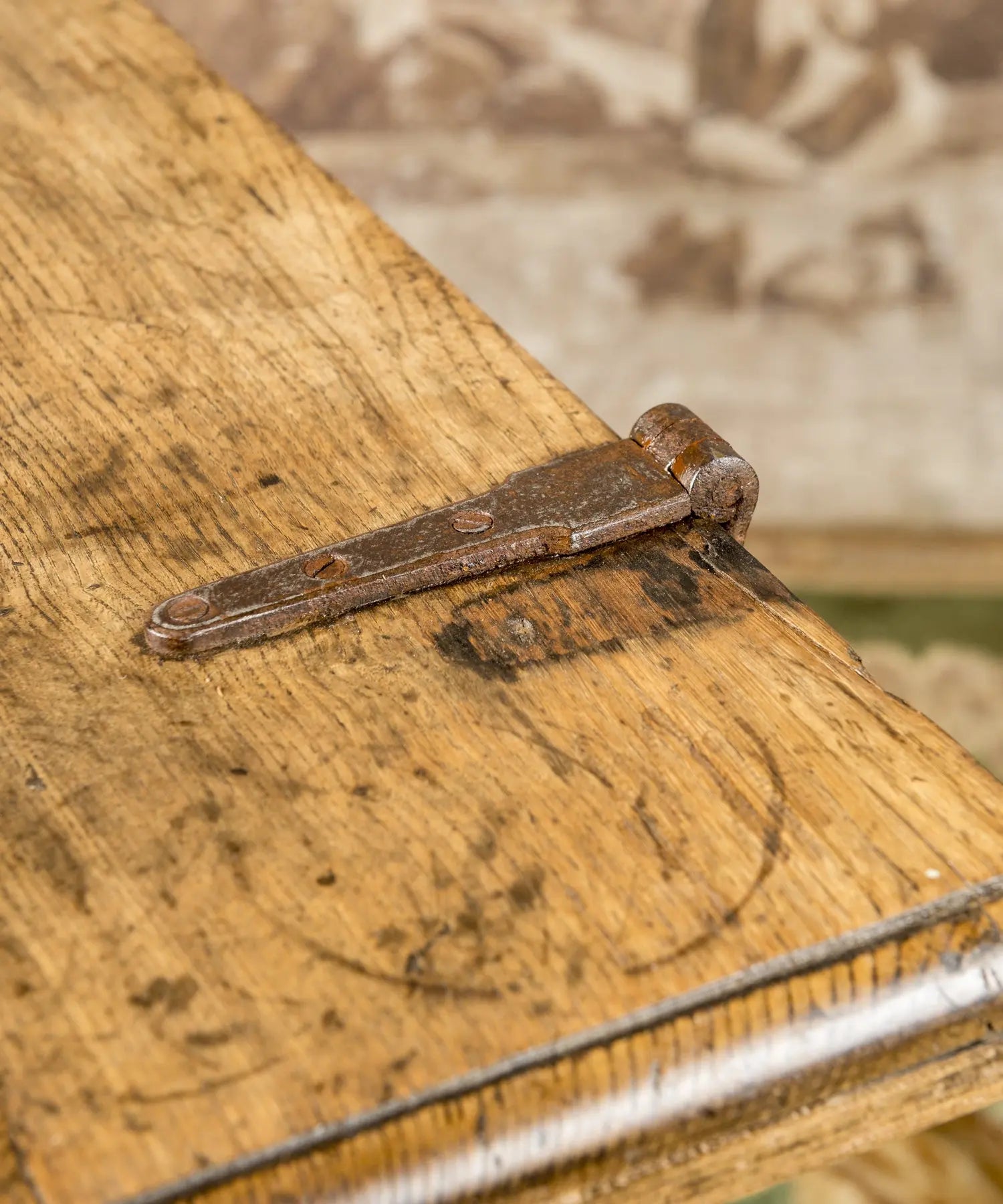 Perfil de mesa masera antigua mostrando la estructura de las patas en X y el acabado de la madera.