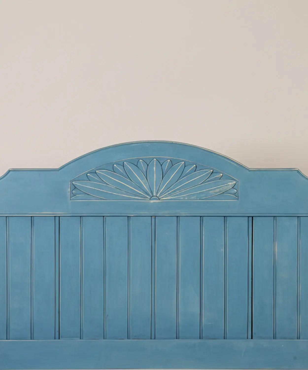Primer plano de talla decorativa en forma de abanico en cabecero rústico
