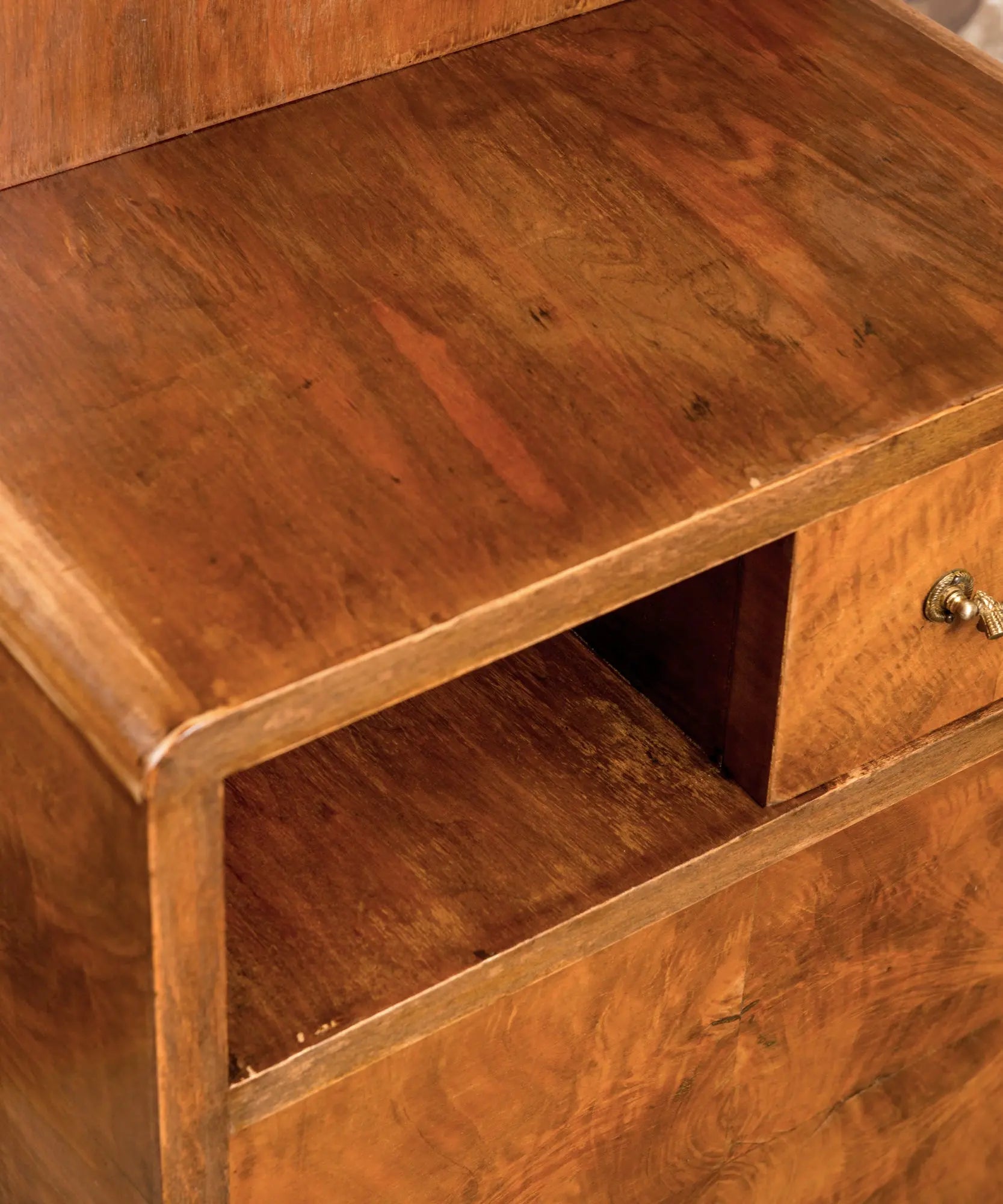 Primer plano de la veta de madera de raíz de nogal y tirador clásico en cajón vintage.