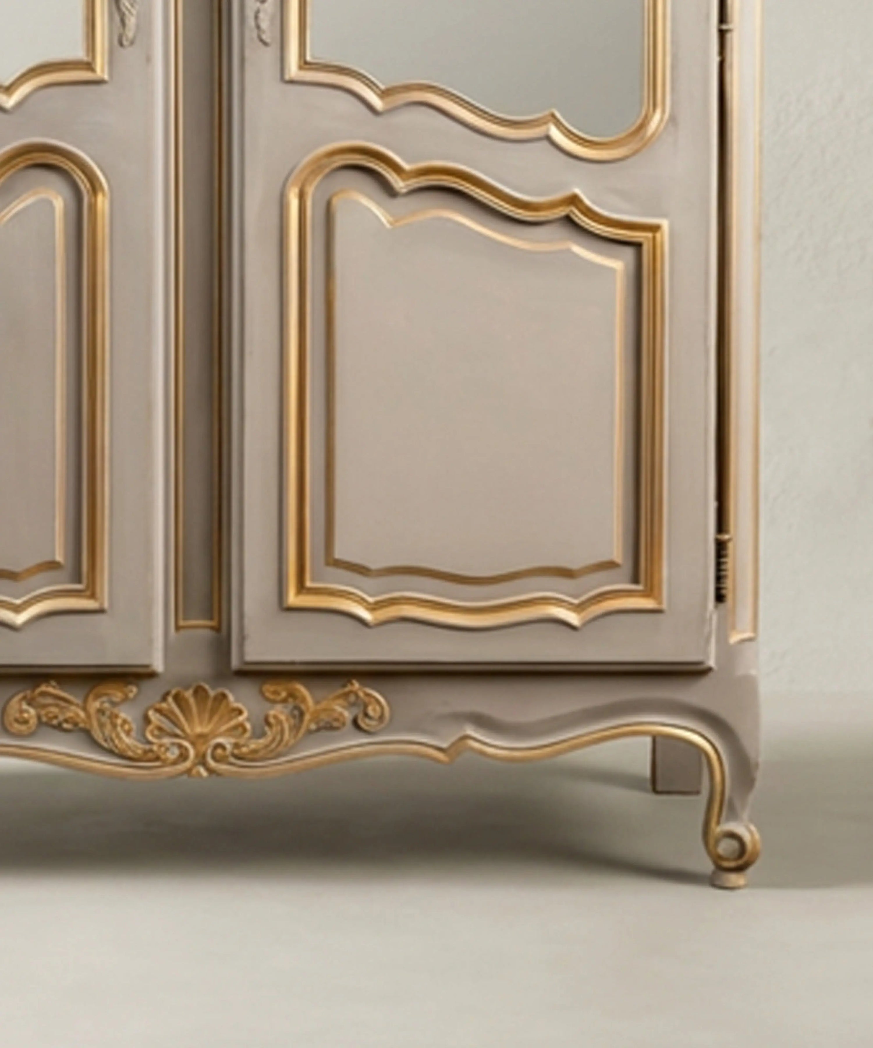 Detalle de faldón con talla de concha dorada y pata cabriolé en vitrina antigua restaurada.