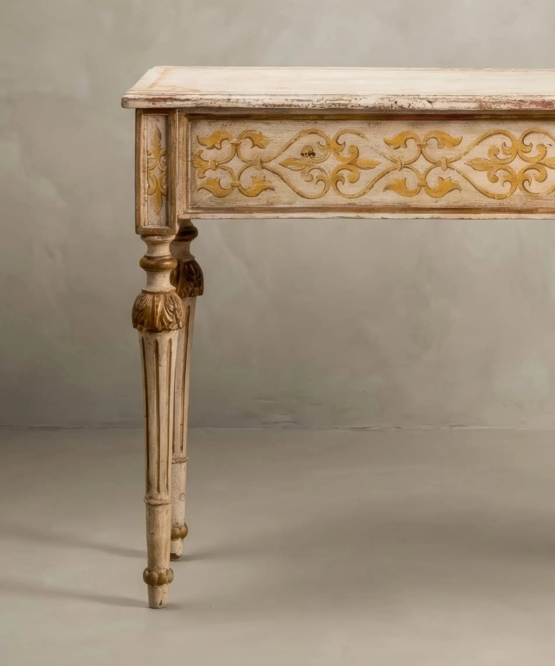 Talla detallada de hojas de acanto doradas sobre fuste estriado de madera envejecida.