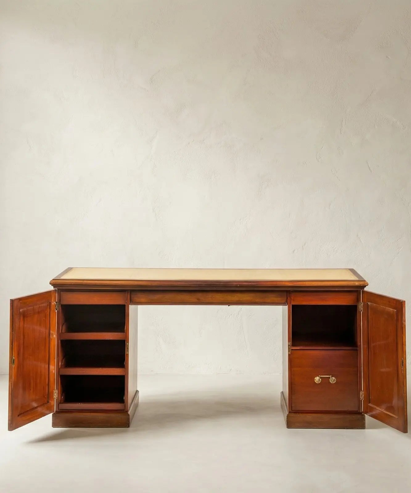 Detalle del interior de los pedestales del escritorio, mostrando estantes de madera y cajón con tirador de latón.