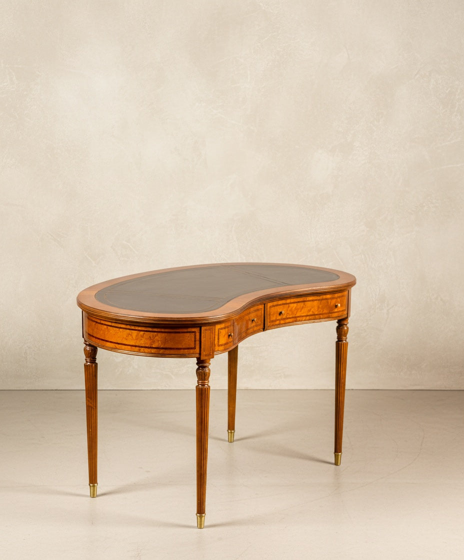 Escritorio de riñón estilo Luis XVI visto de frente mostrando la curvatura y los dos cajones de marquetería.