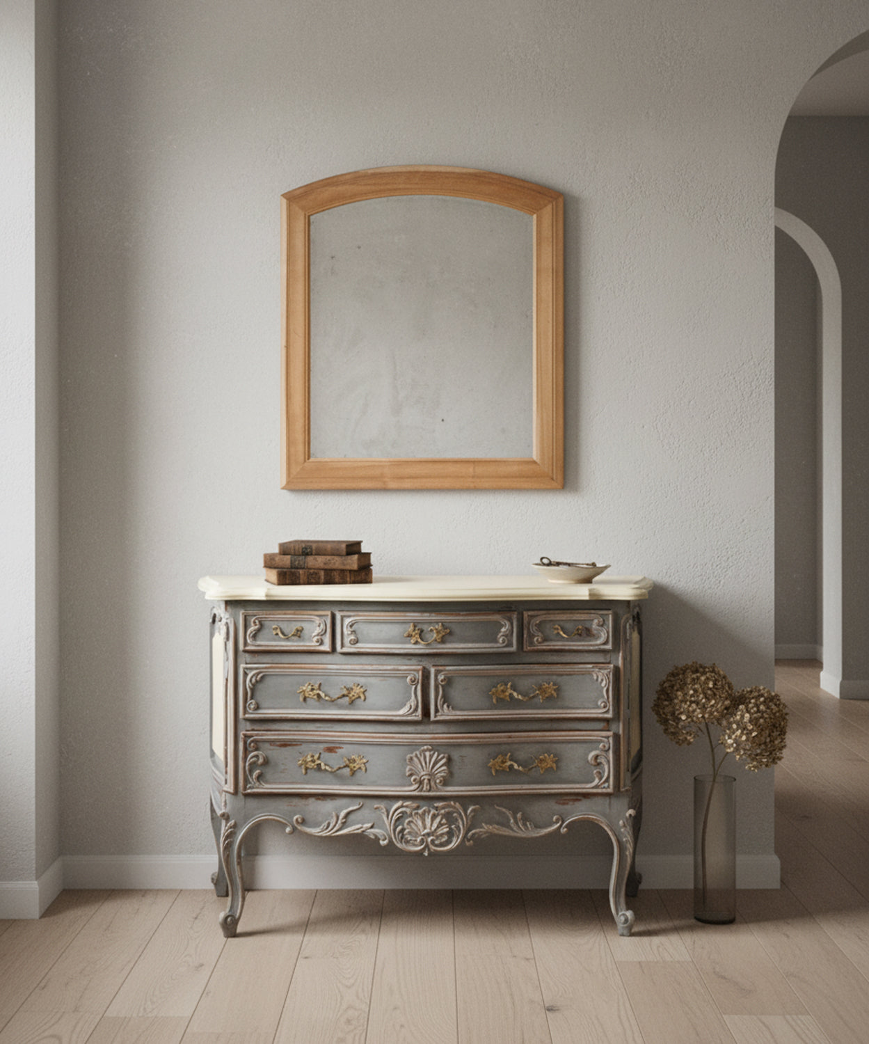 Espejo de madera natural sobre cómoda vintage gris en un salón elegante