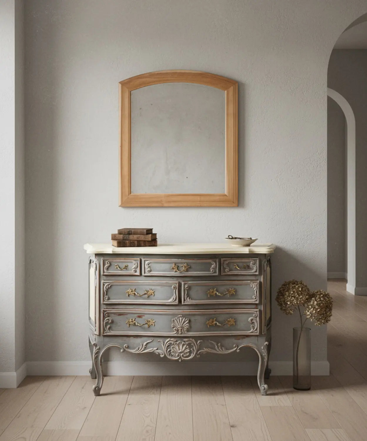 Espejo de madera natural sobre cómoda vintage gris en un salón elegante