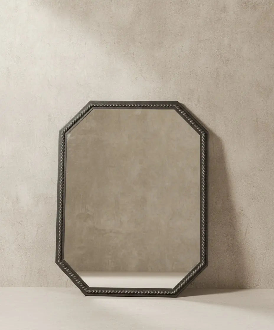 Espejo octogonal de pared con marco de madera trenzado estilo vintage sobre fondo neutro, detalle del acabado peltre.