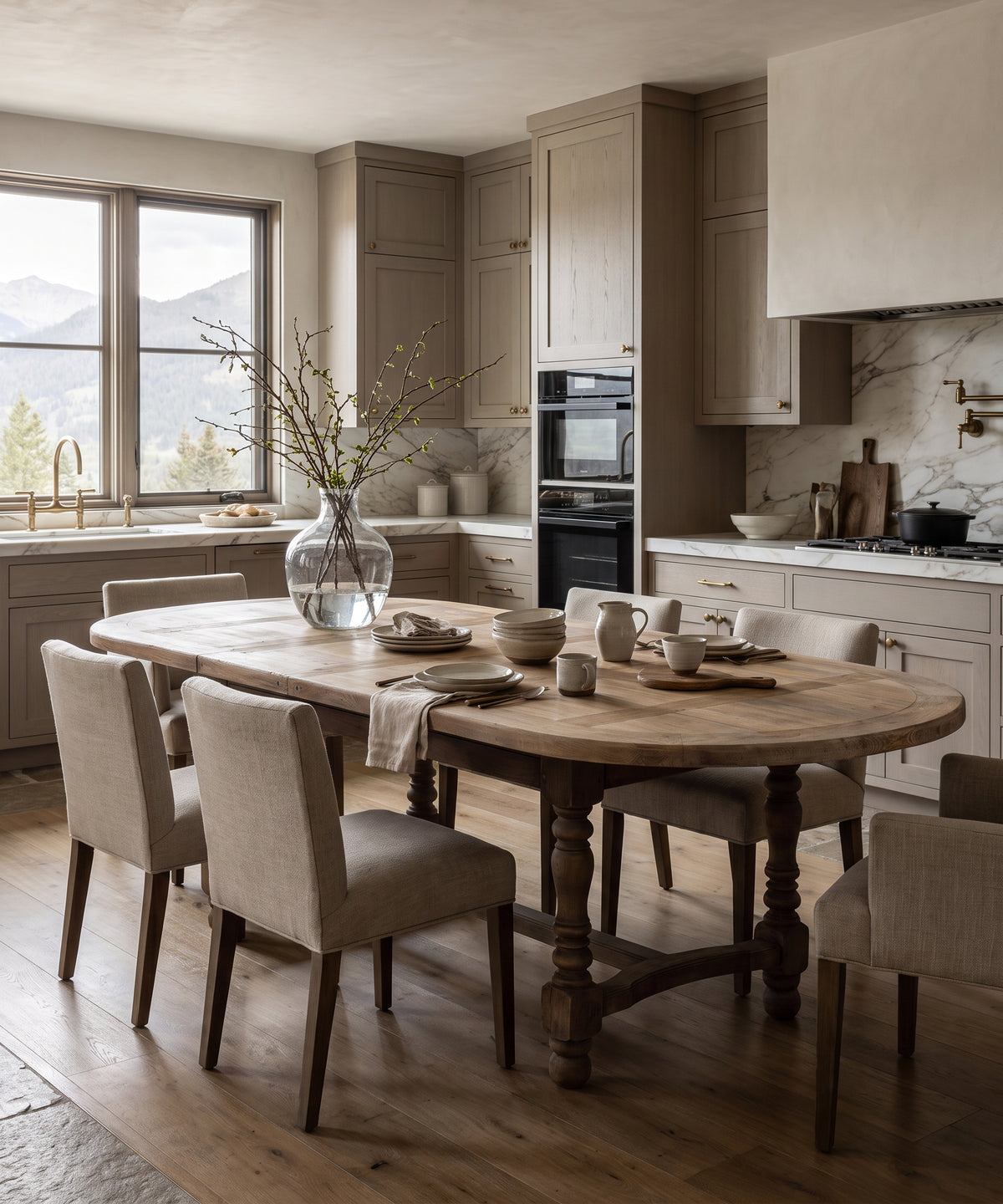 Mesa de comedor ovalada de roble lavado con tablero de parquet en una cocina con sillas tapizadas — Antique Arte y Decoración