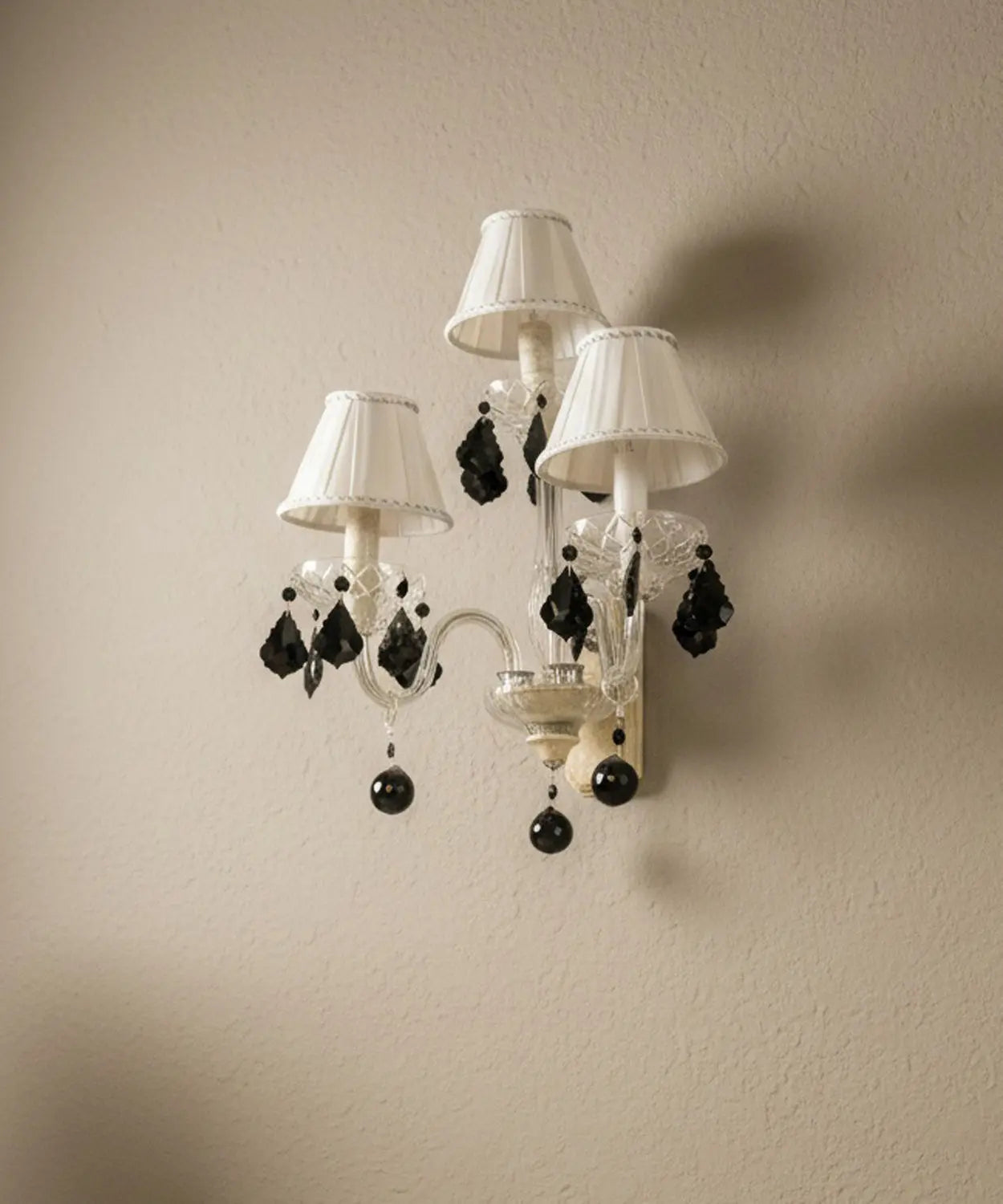 Vista en ángulo del aplique donde se aprecia la transparencia del cristal y la calidad de las lágrimas tipo "jet black".