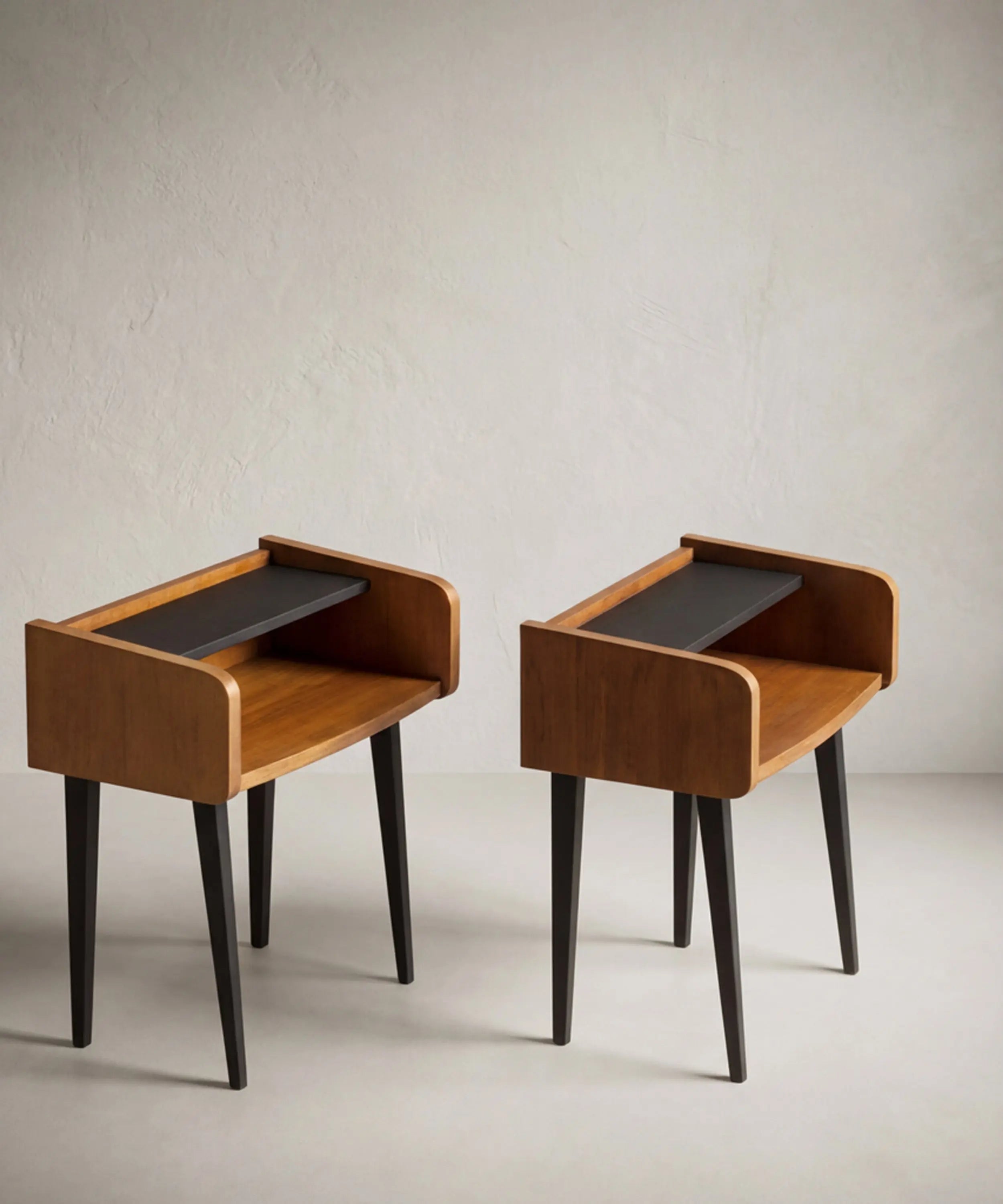 Mesita auxiliar años 60 diseño curvo abierto en madera cálida y estante negro.