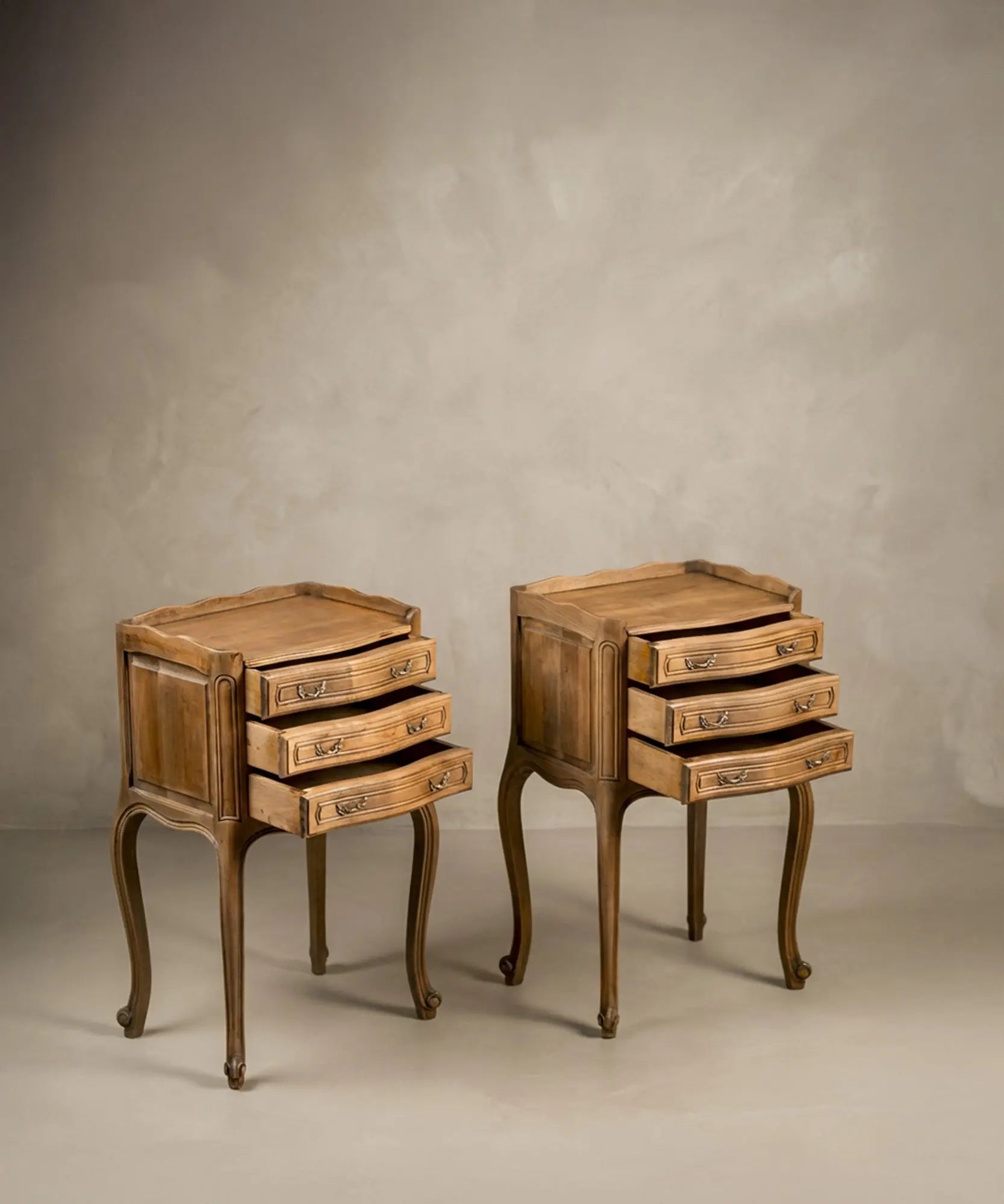 Vista lateral de las mesitas resaltando la curvatura de las patas cabriolé y el diseño bombée.