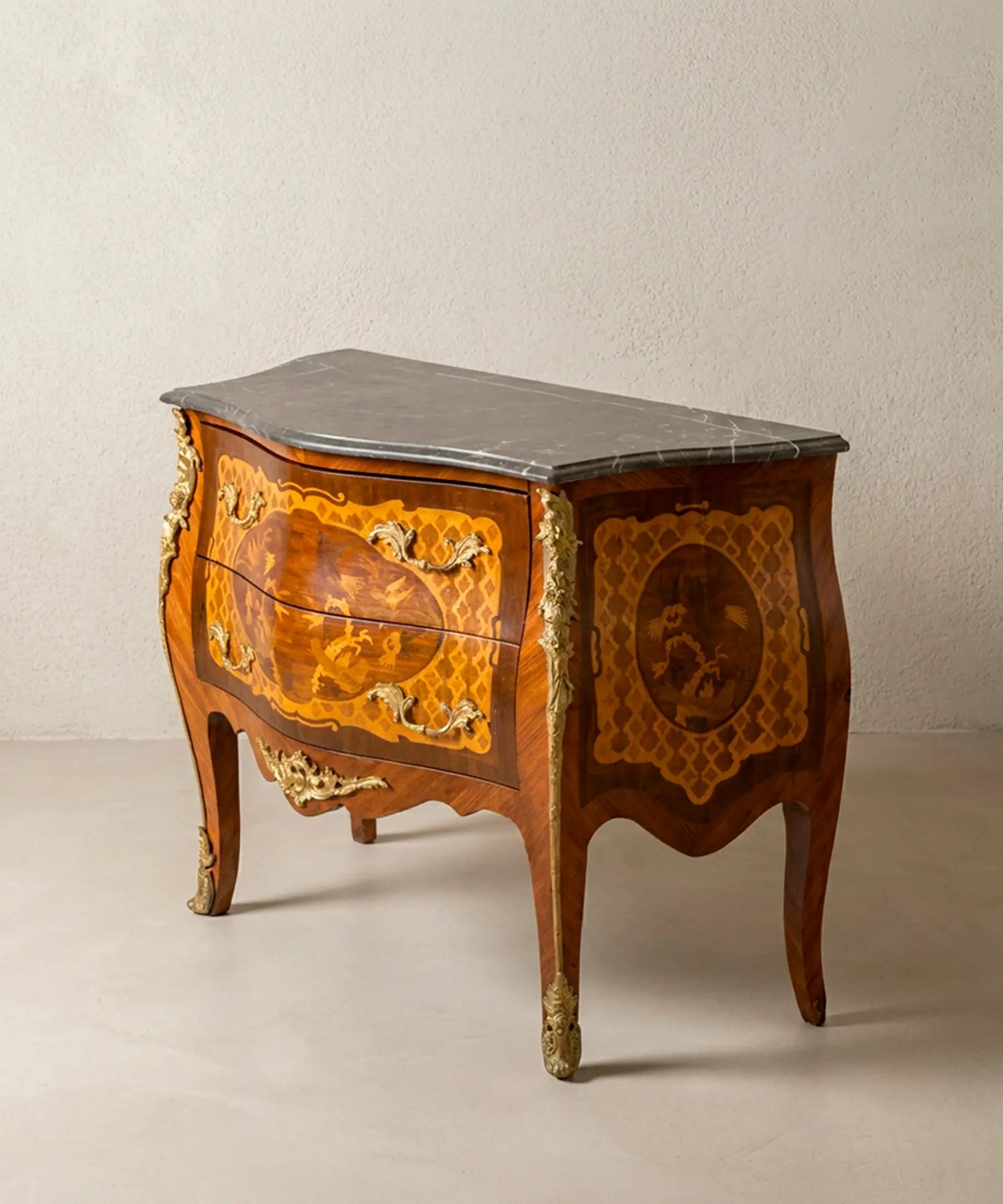Cómoda de palo de rosa con bronces dorados vista lateral y faldón ondulado — Antique Arte y Decoración