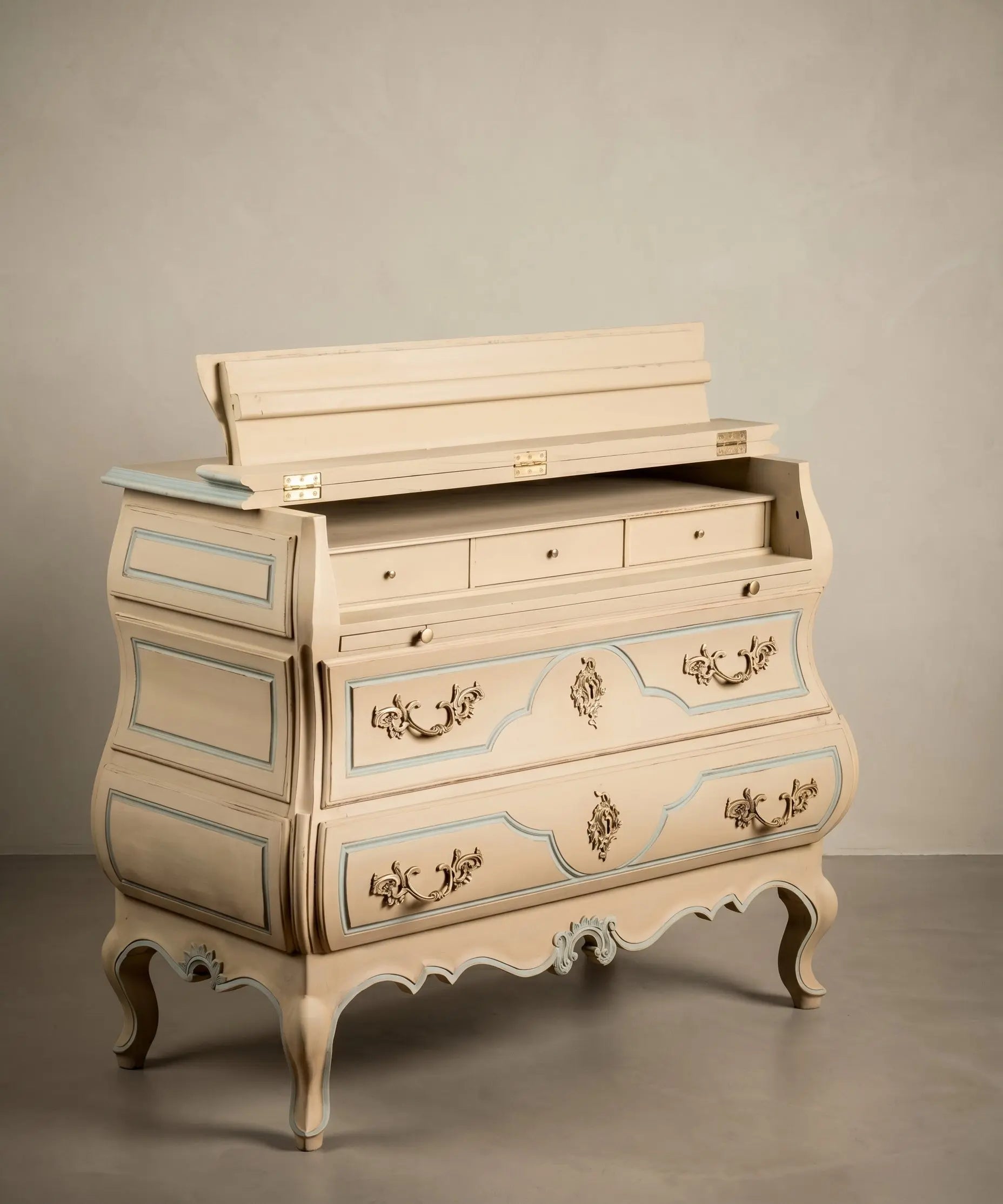 : Cómoda secreter vintage abierta mostrando su interior de escritorio con cajoncitos y tapete de cuero.