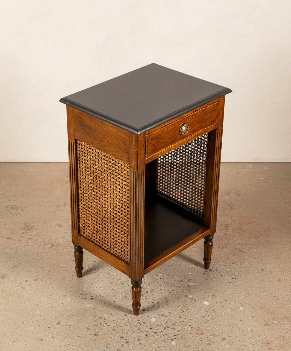 Primer plano del tirador de bronce y la textura de la madera con la tapa negra superior.