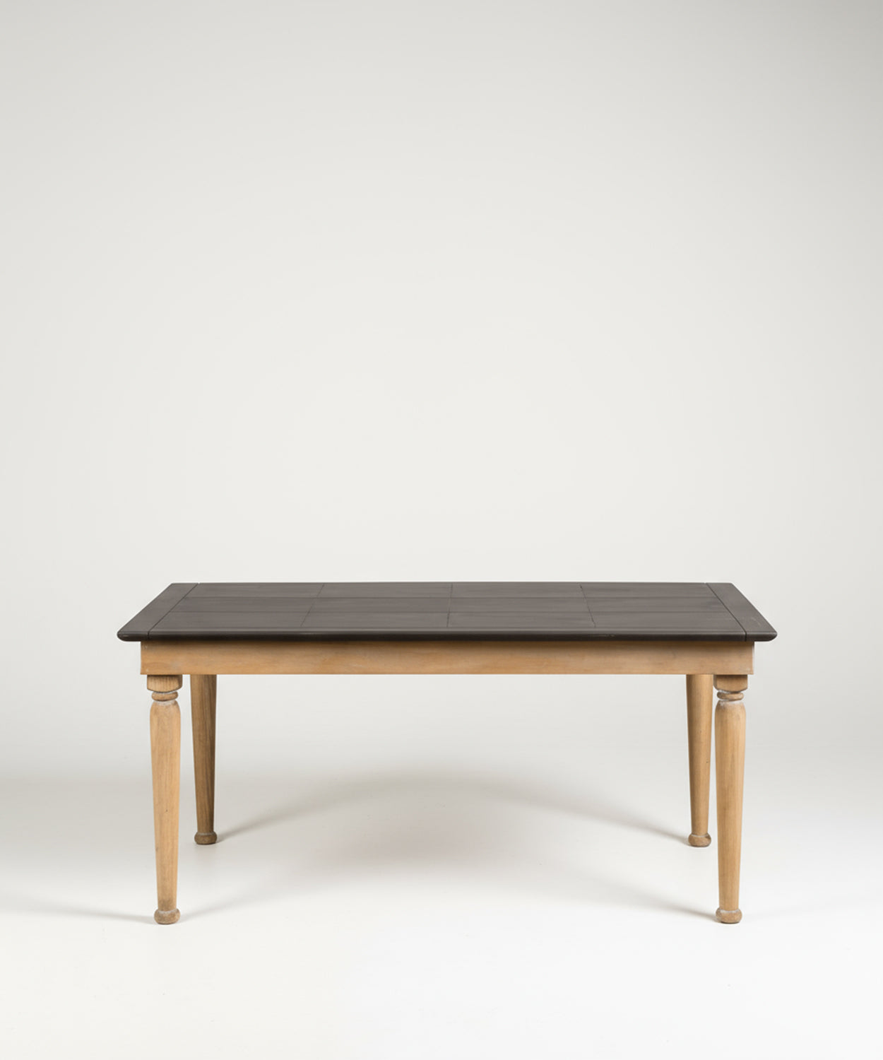 Mesa de comedor rectangular de estilo rústico con patas de madera natural y superficie oscura, fotografiada de frente en un estudio con fondo blanco.