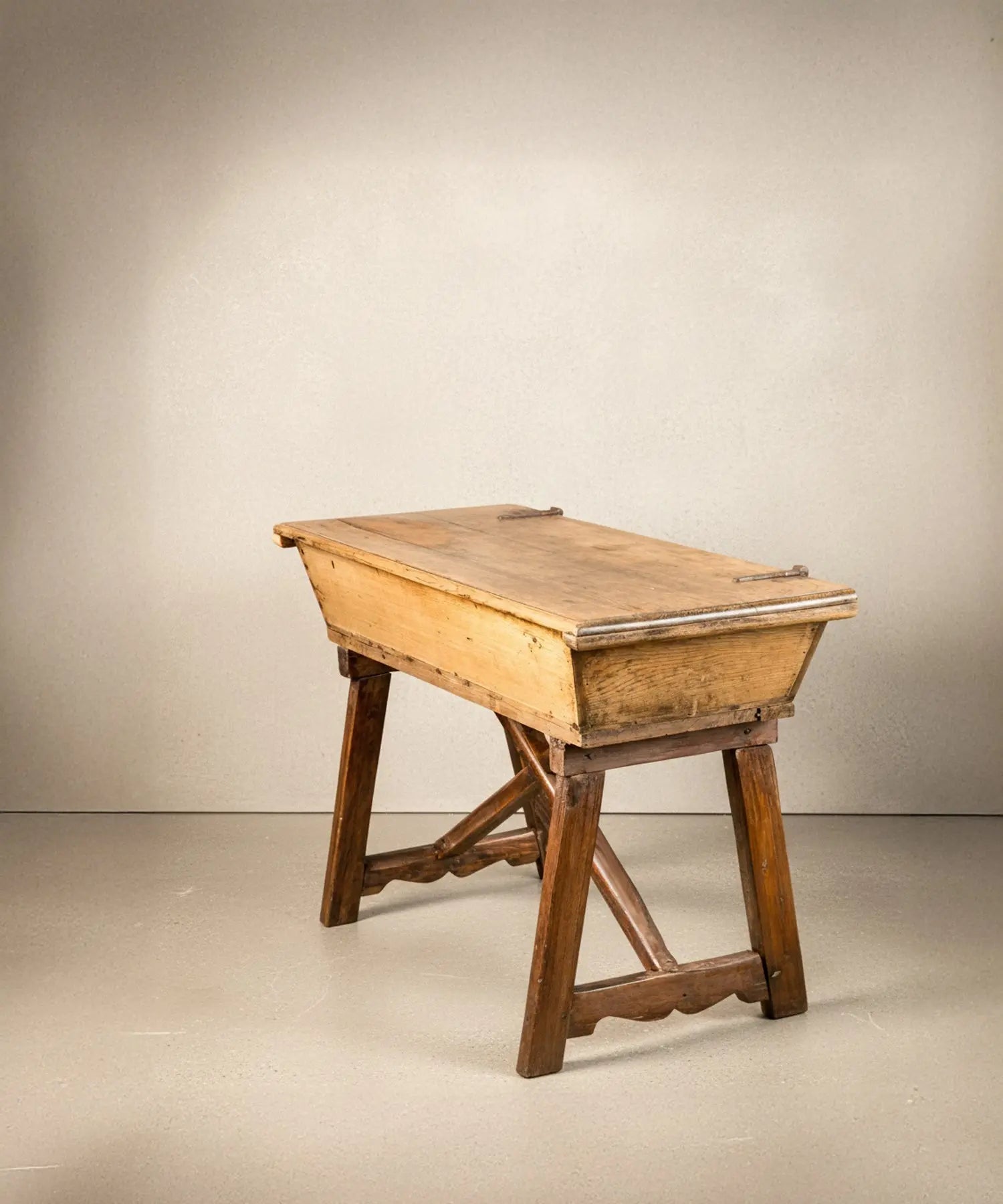 Perfil de mesa masera antigua mostrando la estructura de las patas en X y el acabado de la madera.