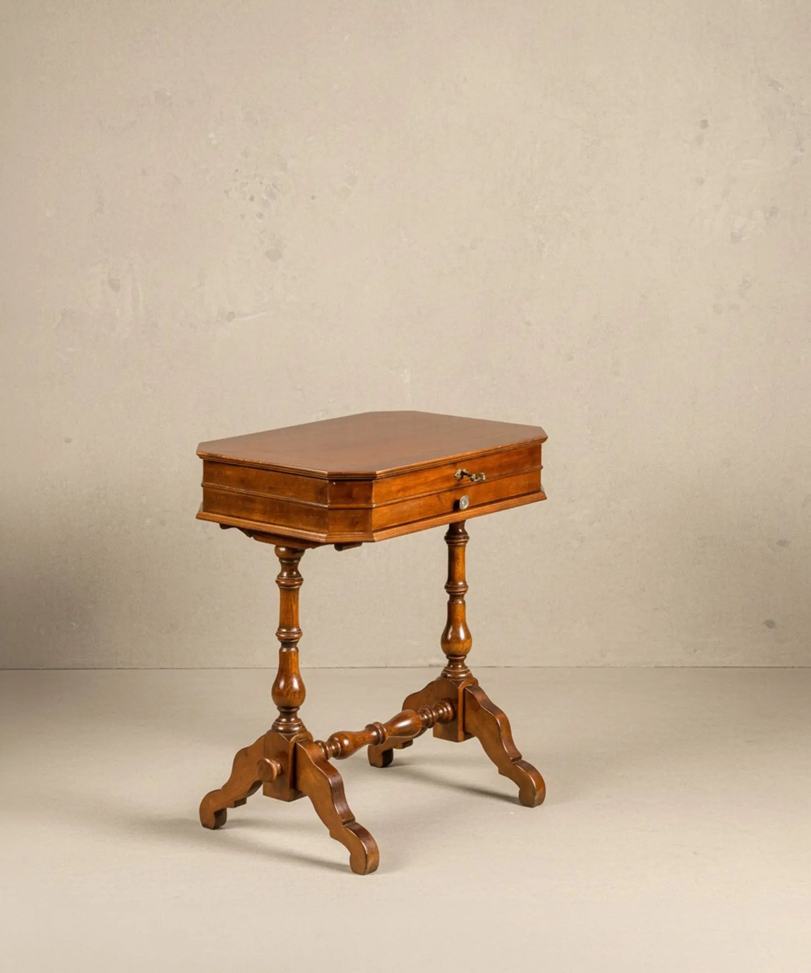 Mesa de costura antigua de madera noble con marquetería floral en la tapa y patas torneadas.