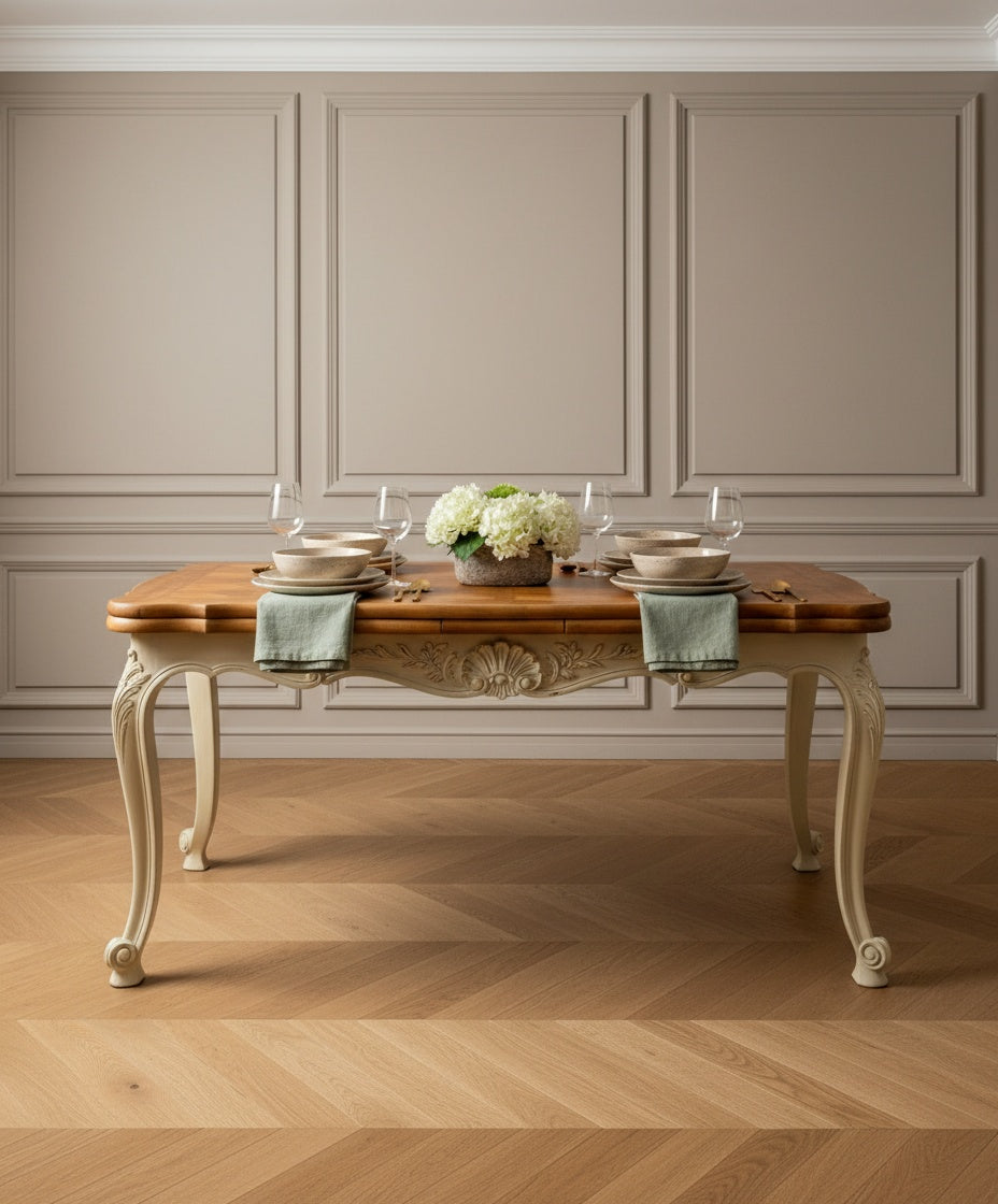 Mesa Luis XV vestida con vajilla clásica en un comedor de techos altos y molduras.