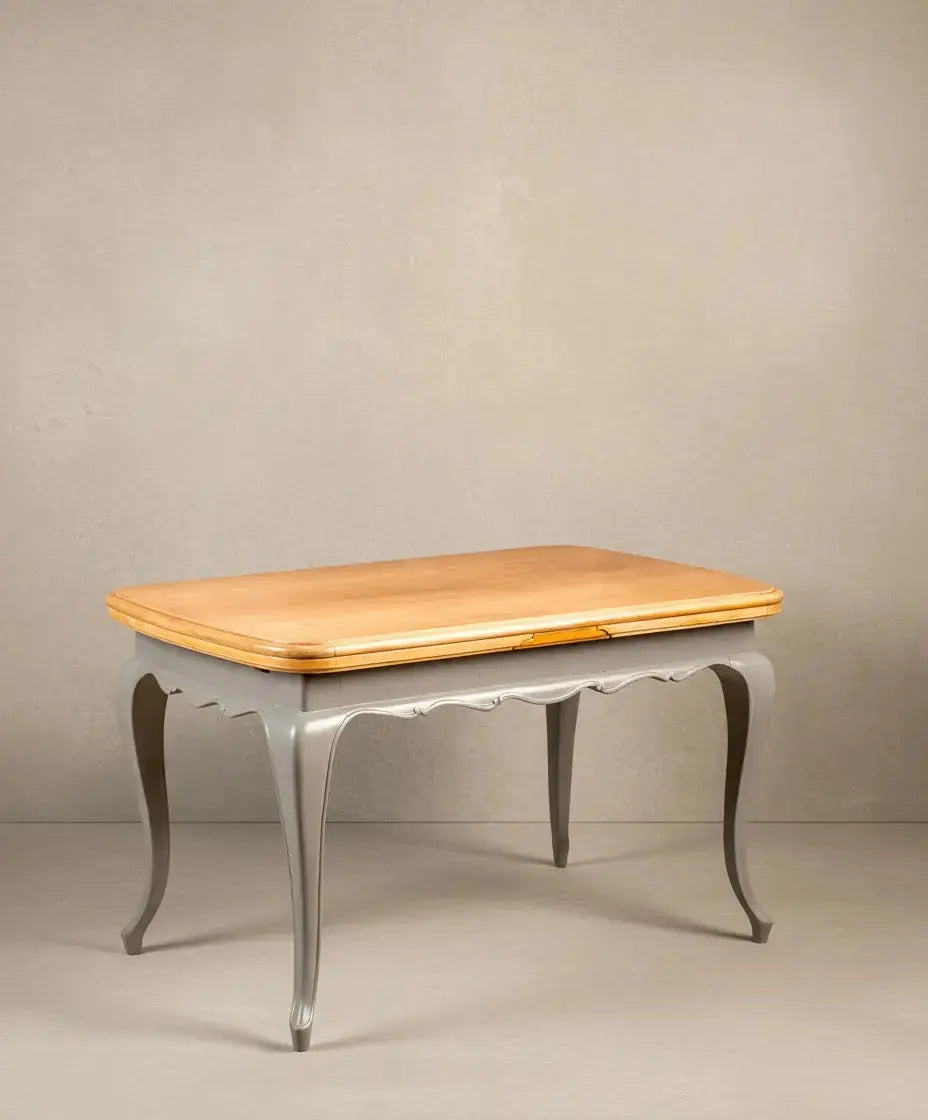Mesa de comedor vintage bicolor con tablero de madera natural y estructura gris, patas curvas.