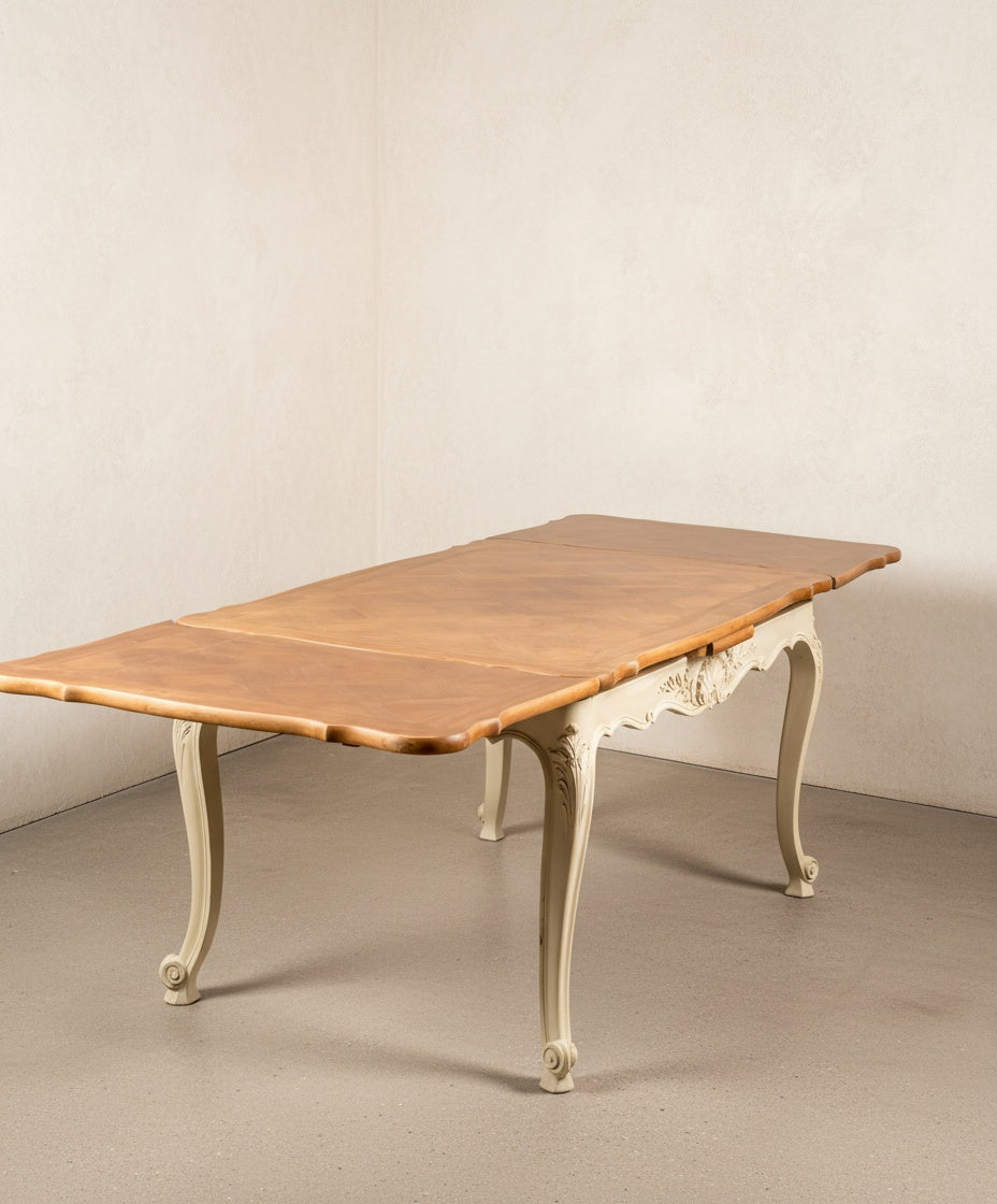 Vista de la mesa de comedor francesa con las extensiones abiertas mostrando el mecanismo y la veta de la madera.