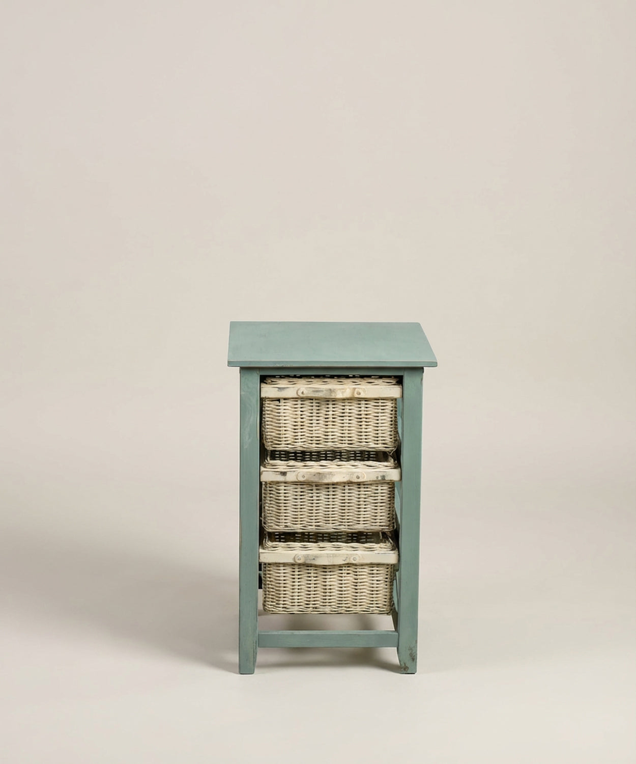 Primer plano frontal de los tres cajones de cesta de mimbre trenzado en la estructura de madera