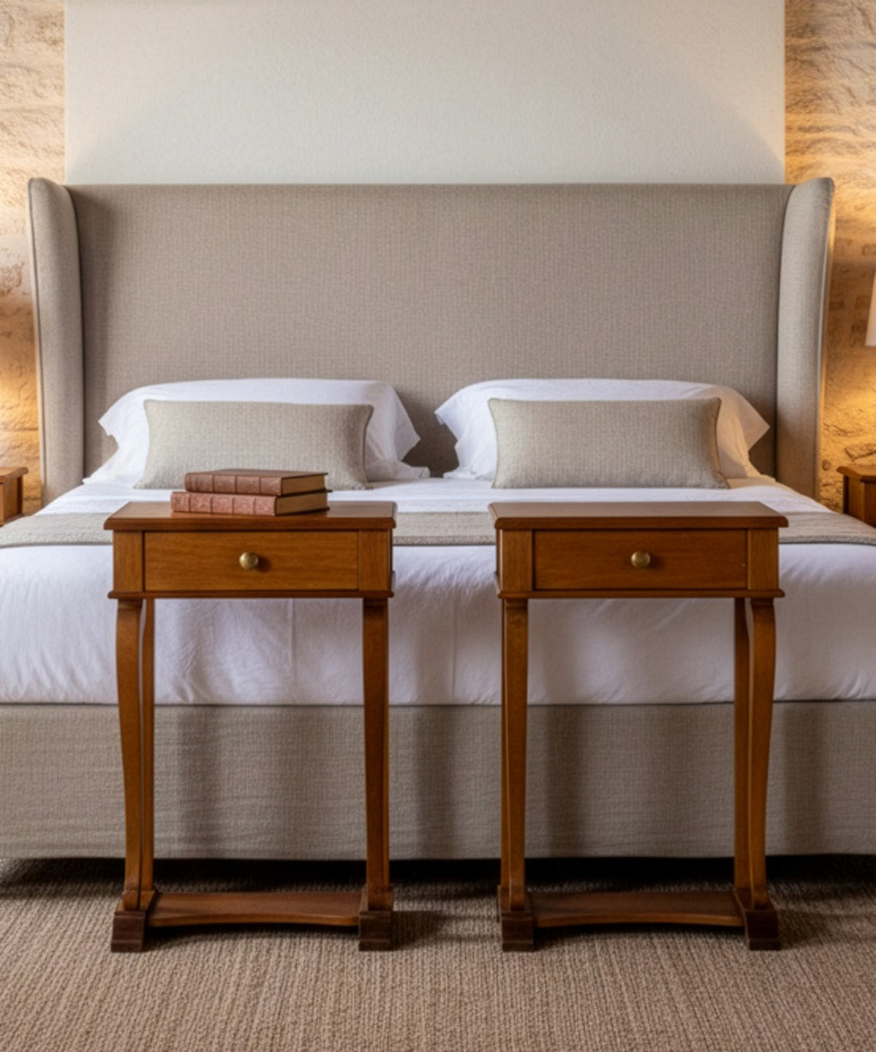 Mesitas de noche integradas en un dormitorio de tonos neutros junto a una cama con cabecero textil.