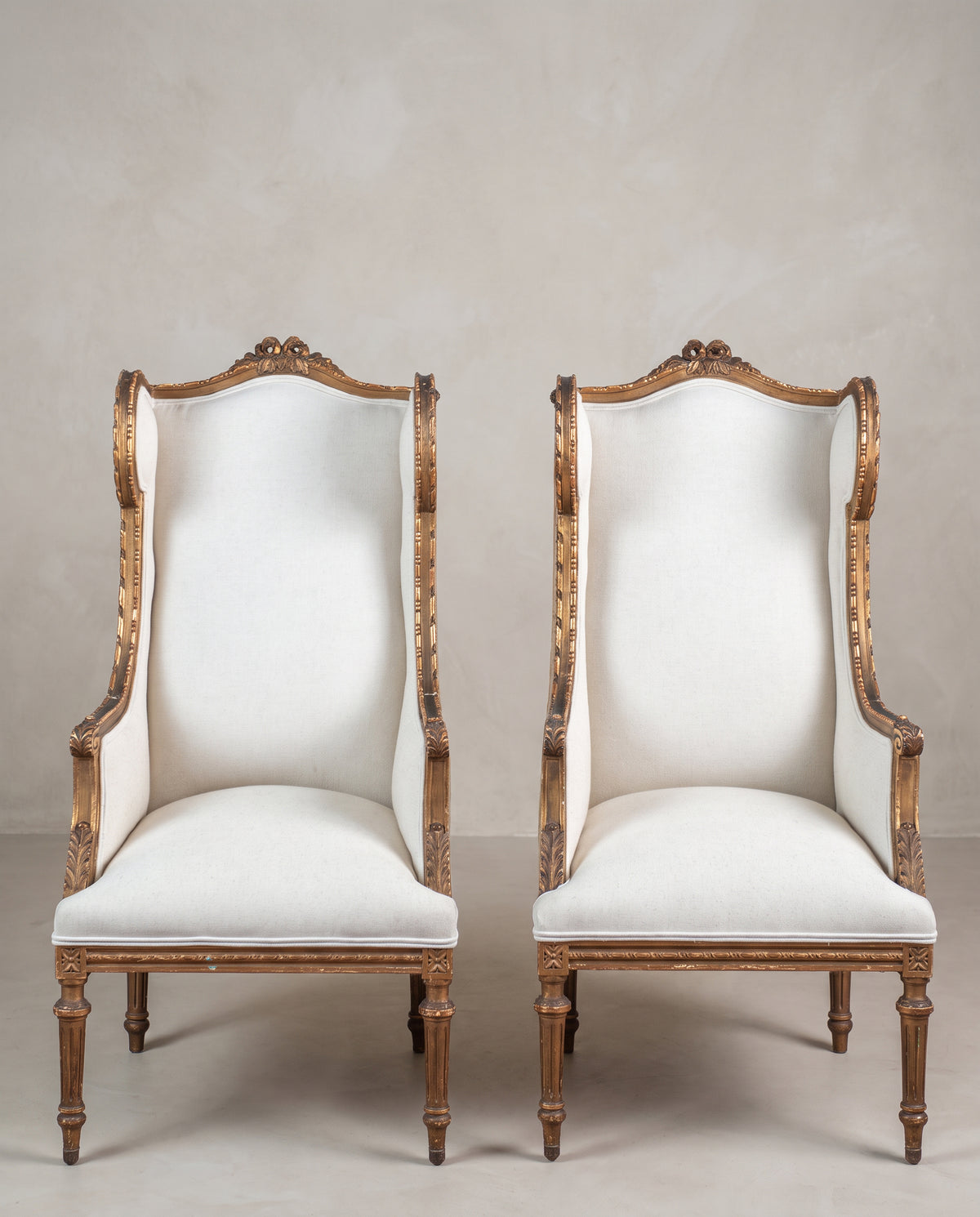 Pareja de sillones orejeros antiguos Luis XVI dorados al pan de oro vista frontal — Antique Arte y Decoración