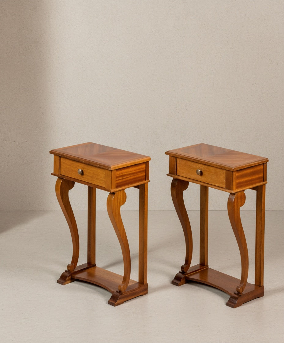 Vista lateral de las mesitas mostrando la curvatura elegante de las patas y el acabado brillante de la madera.