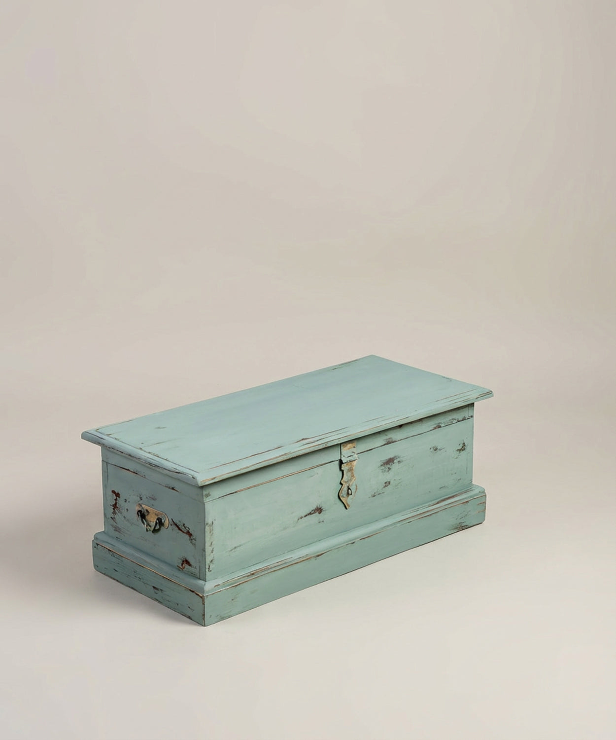 Vista en perspectiva del baúl verde agua mostrando asa lateral y textura envejecida