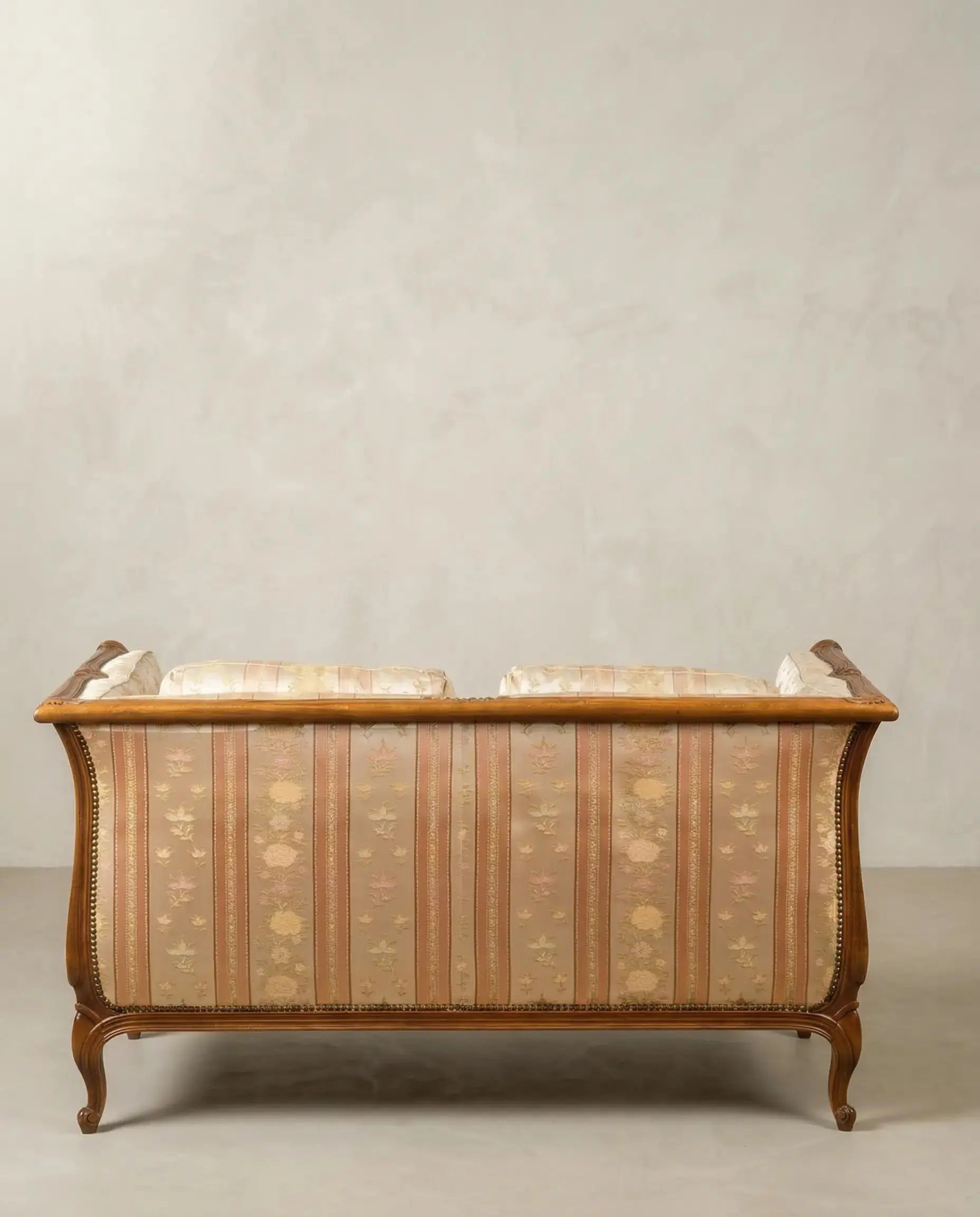 Parte posterior del respaldo tapizado de sofá estilo francés con estructura de madera vista.