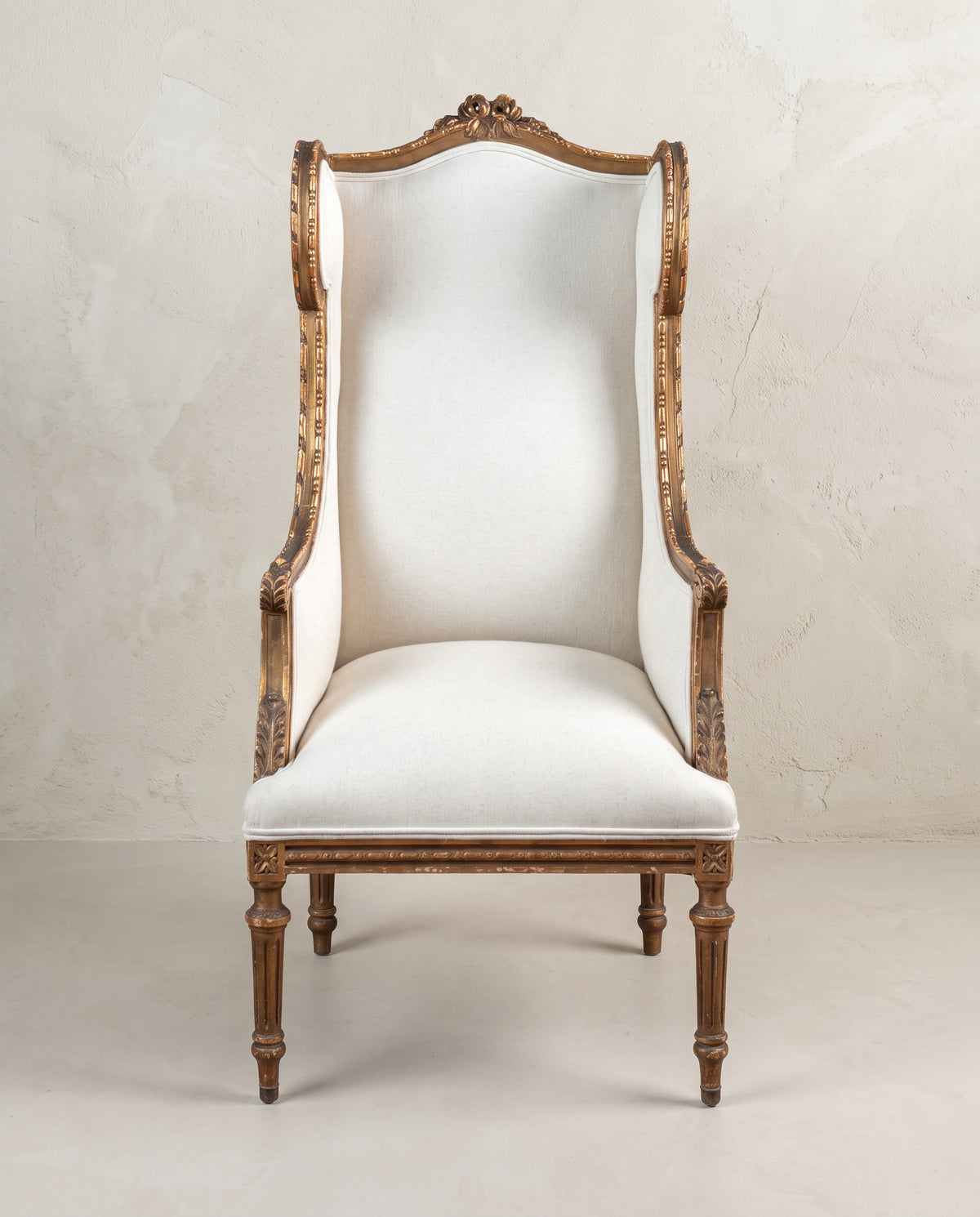 Sillón orejero antiguo Luis XVI dorado al pan de oro vista frontal, tapizado en lino — Antique Arte y Decoración