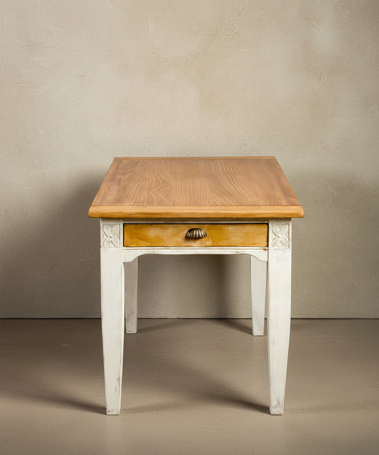 Ángulo lateral frontal
mostrando la veta natural del sobre de madera maciza y el acabado envejecido de las patas.