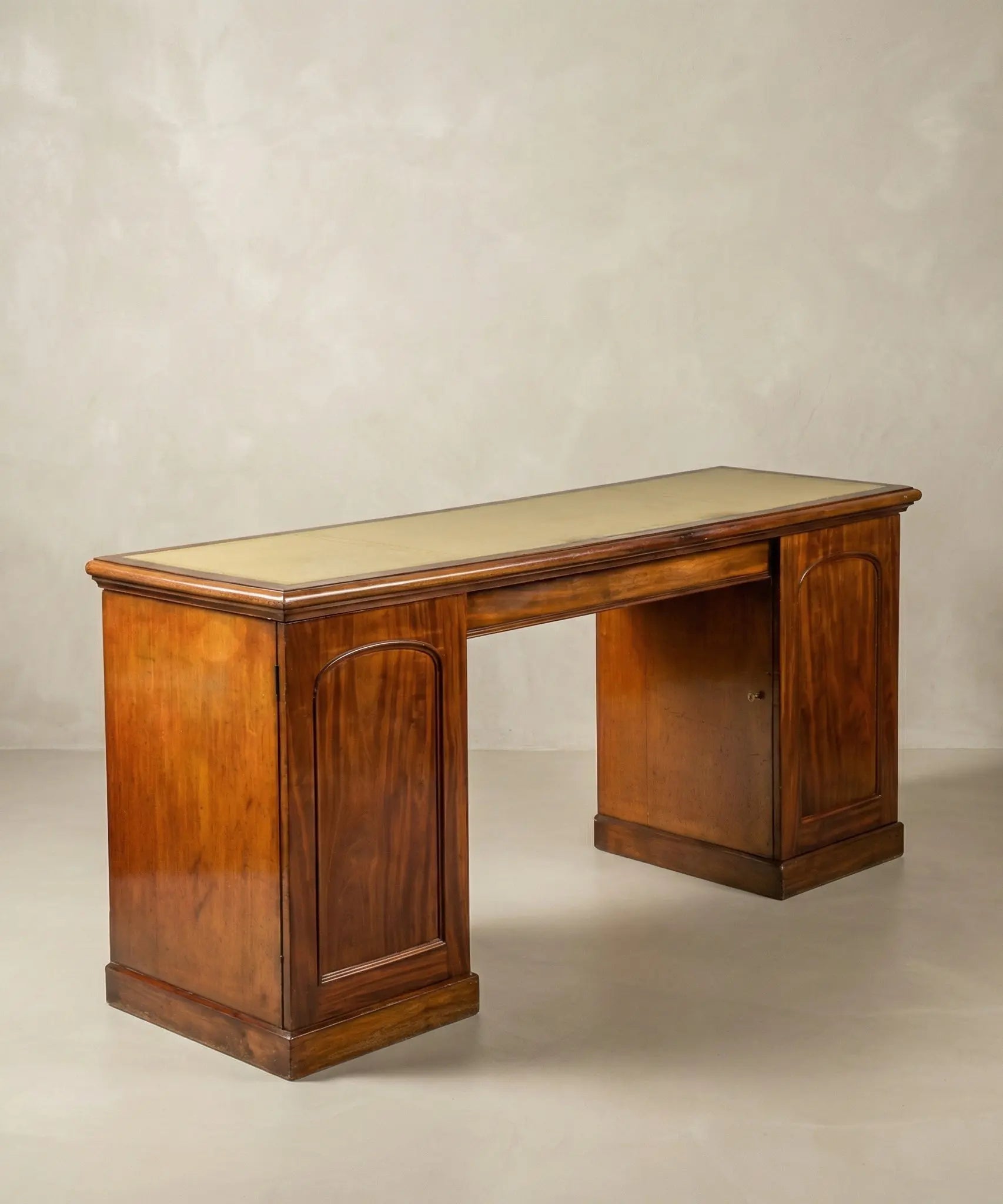 Escritorio antiguo de doble pedestal en madera de caoba con paneles tallados y diseño clásico.