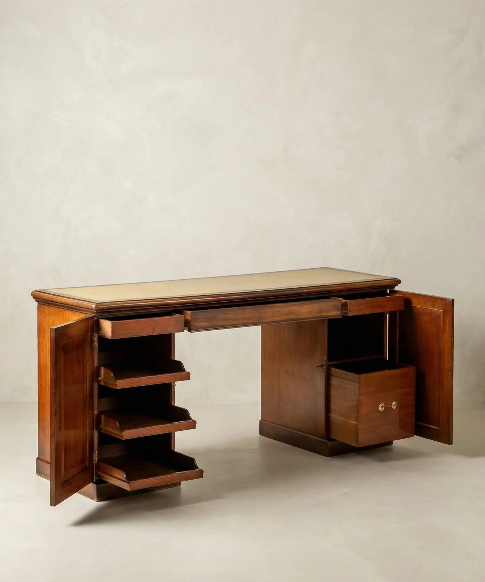 Detalle del interior de los pedestales del escritorio, mostrando estantes de madera y cajón con tirador de latón.