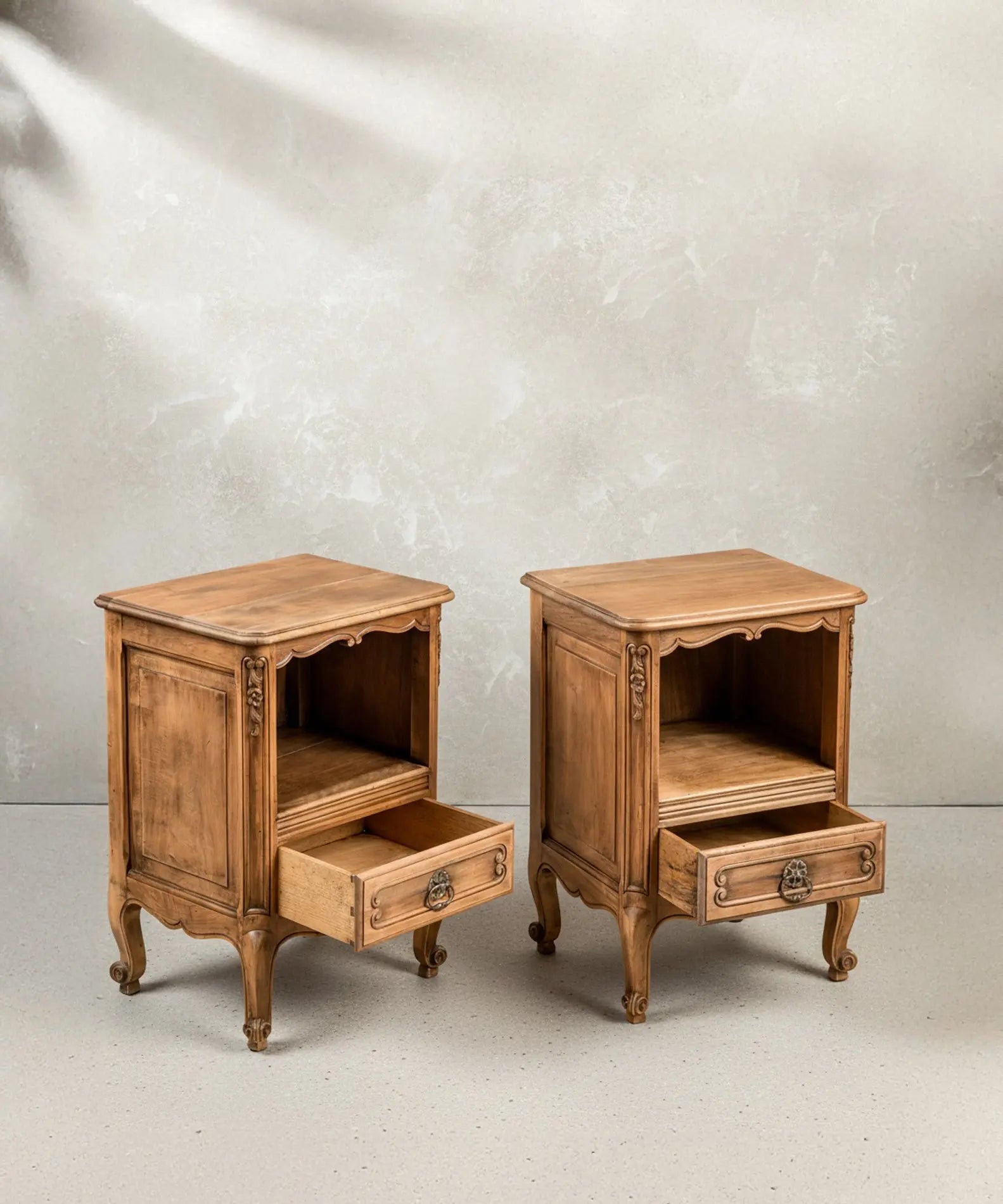 Detalle de los cajones abiertos con tiradores de bronce y el nicho superior de las mesitas vintage.